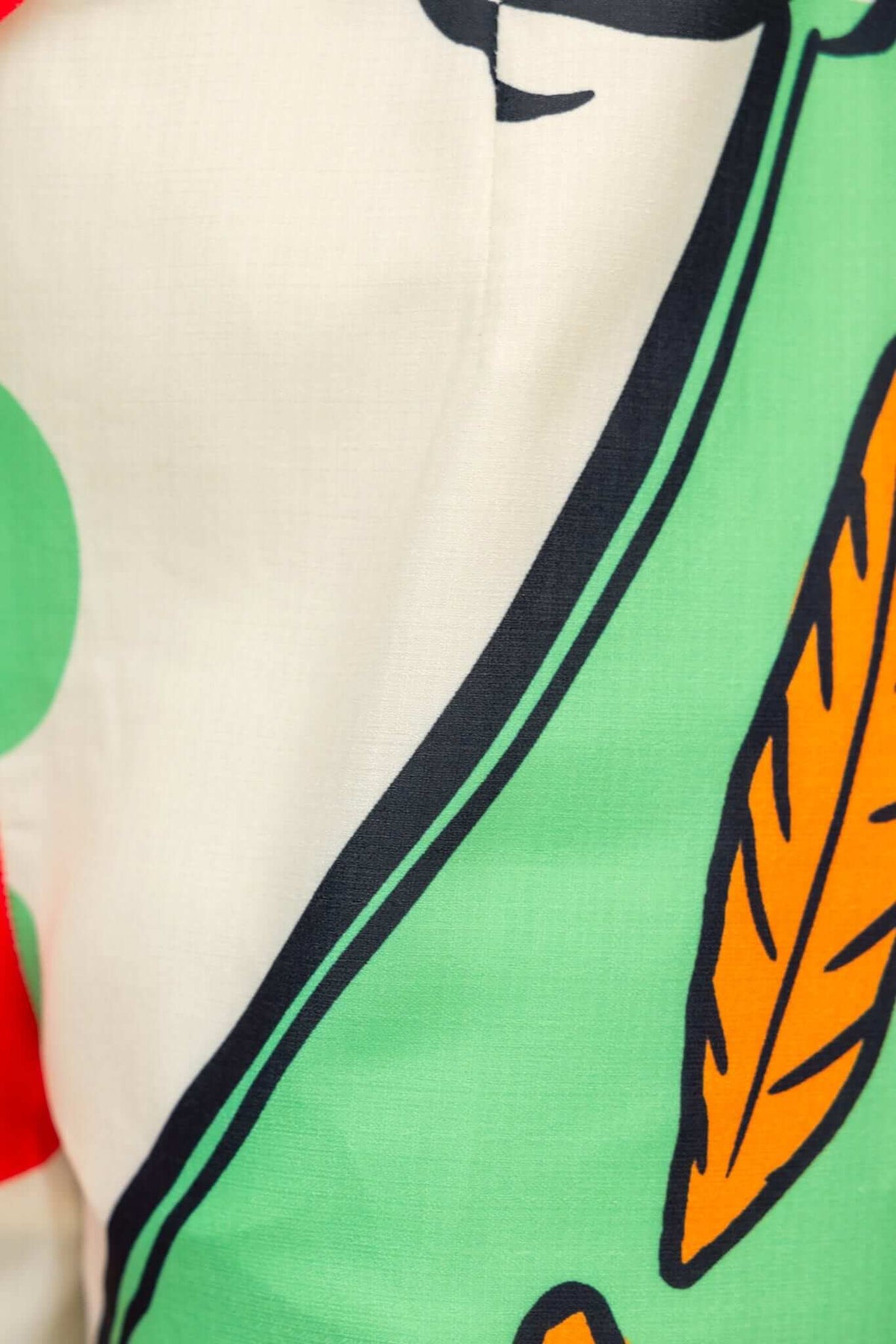 Detail of multi-colour print featuring green leaves and orange elements on the Sun Dazed Jumpsuit.