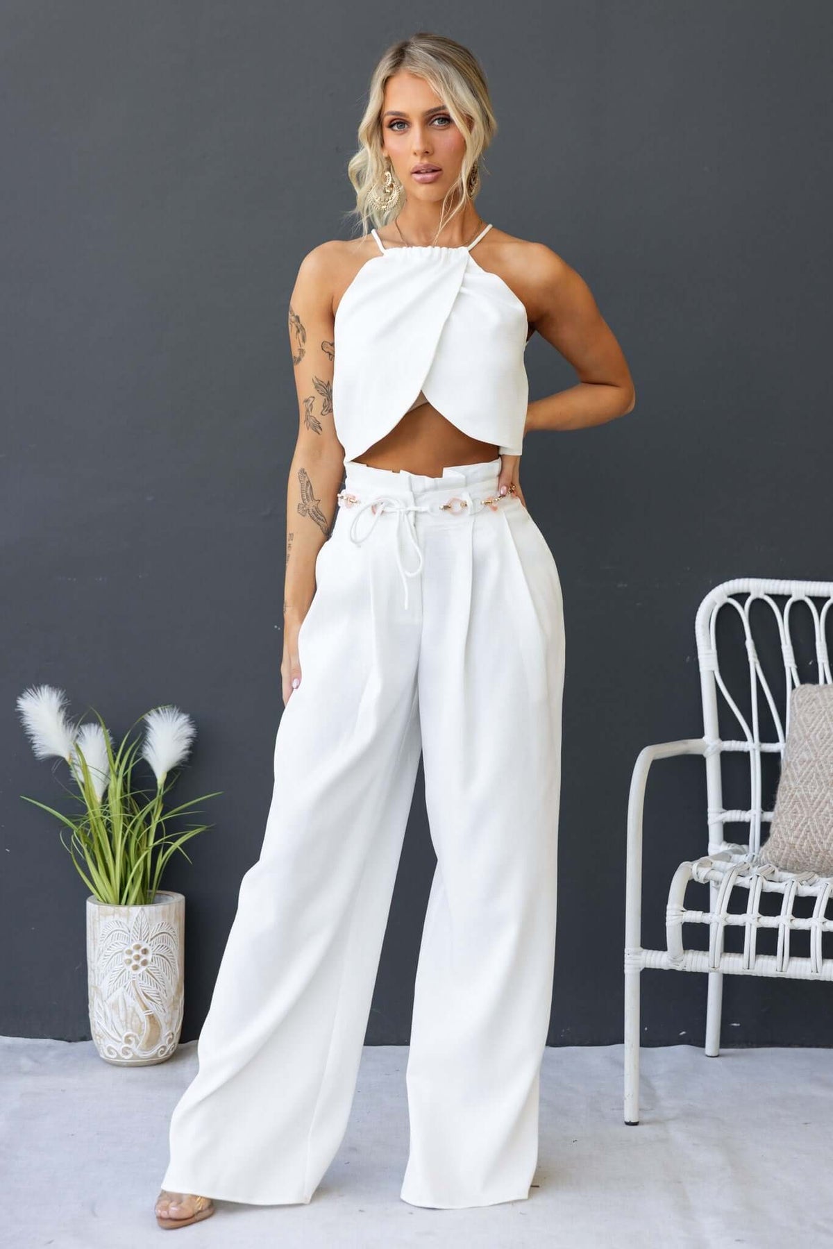 Model wearing Paytas Pants with a paperbag waist and a stylish crop top against a minimalist backdrop.