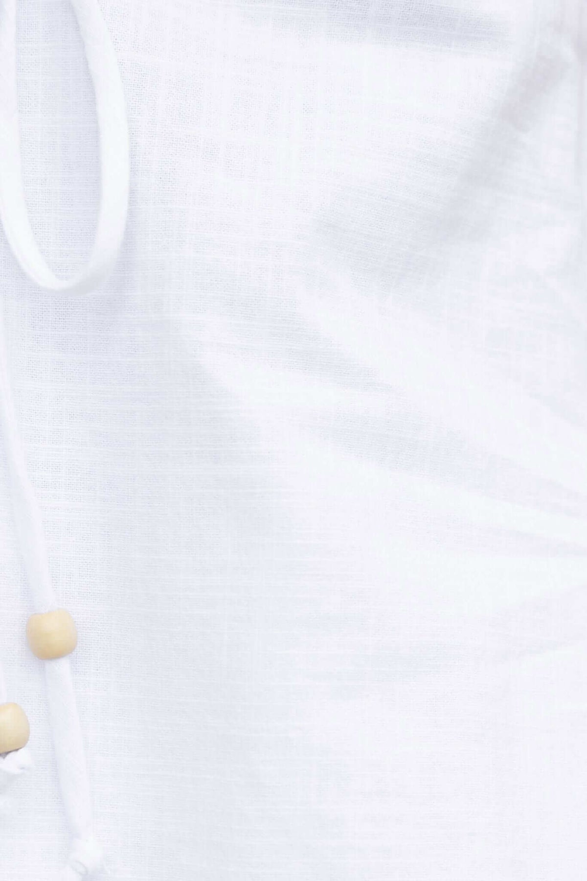 Close-up of the Stelline Top featuring adjustable straps, tie detail at bust, and a soft linen-like texture.
