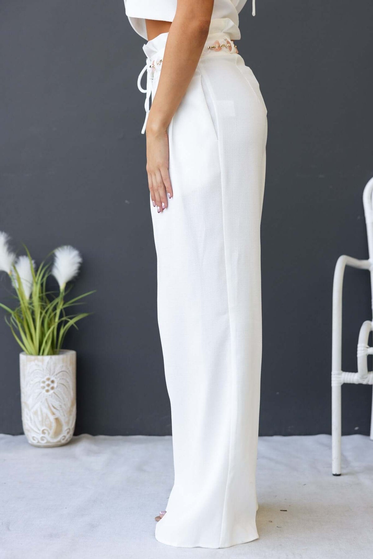 White Paytas Pants with paperbag waist and removable belt, showcased on a model against a simple backdrop.