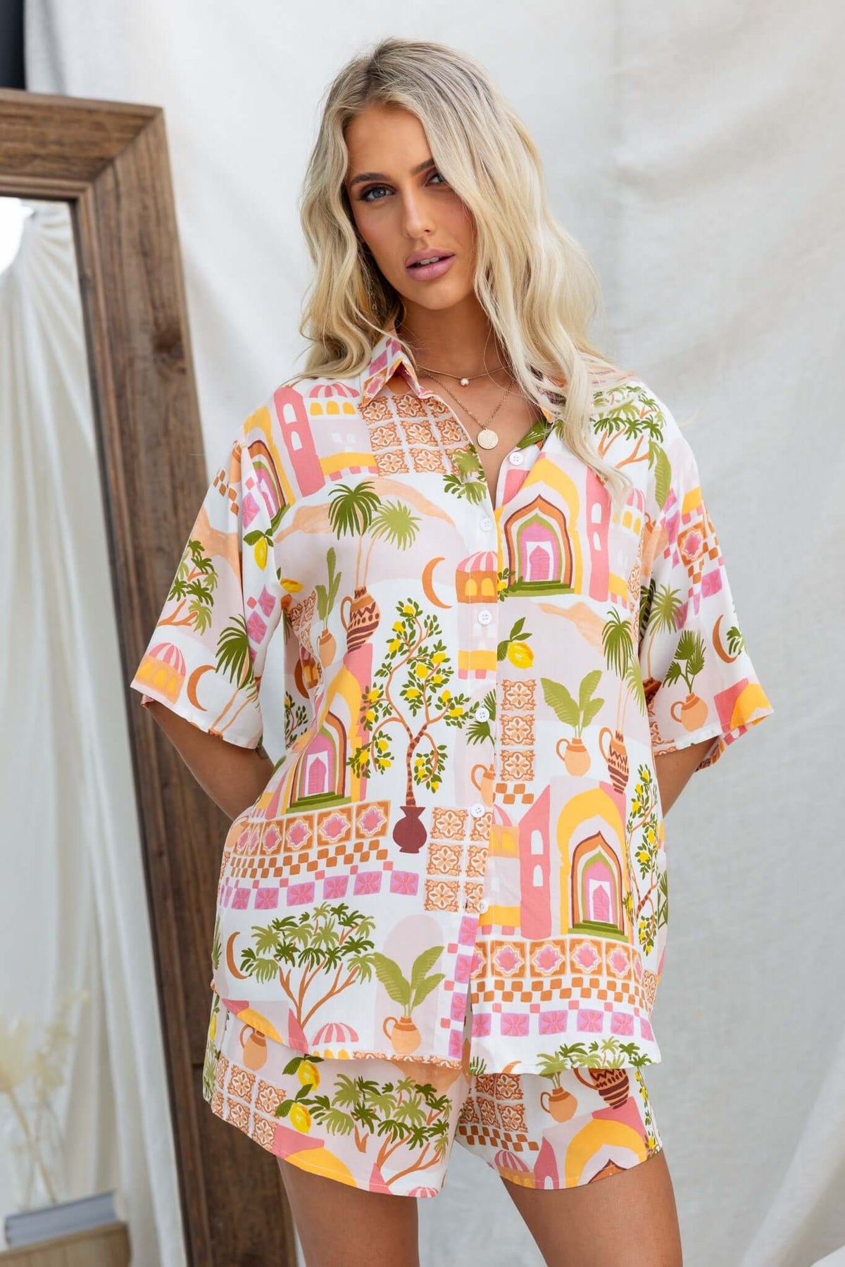 Model wearing the Junia Set featuring a colorful button-up shirt and mid-high waist shorts with floral patterns.