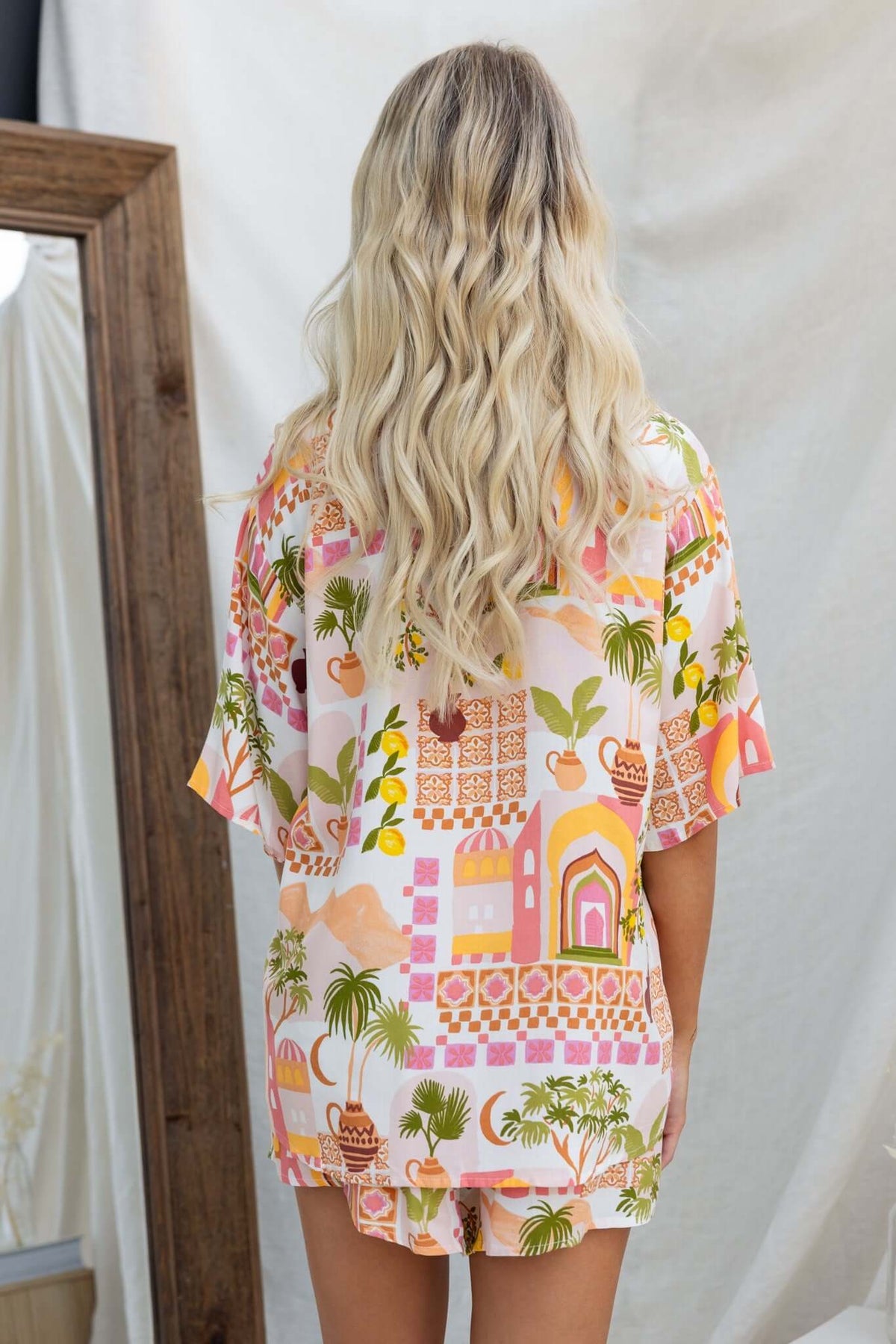 Model wearing the Junia Set featuring a colorful shirt and shorts, showcasing a vibrant tropical design.