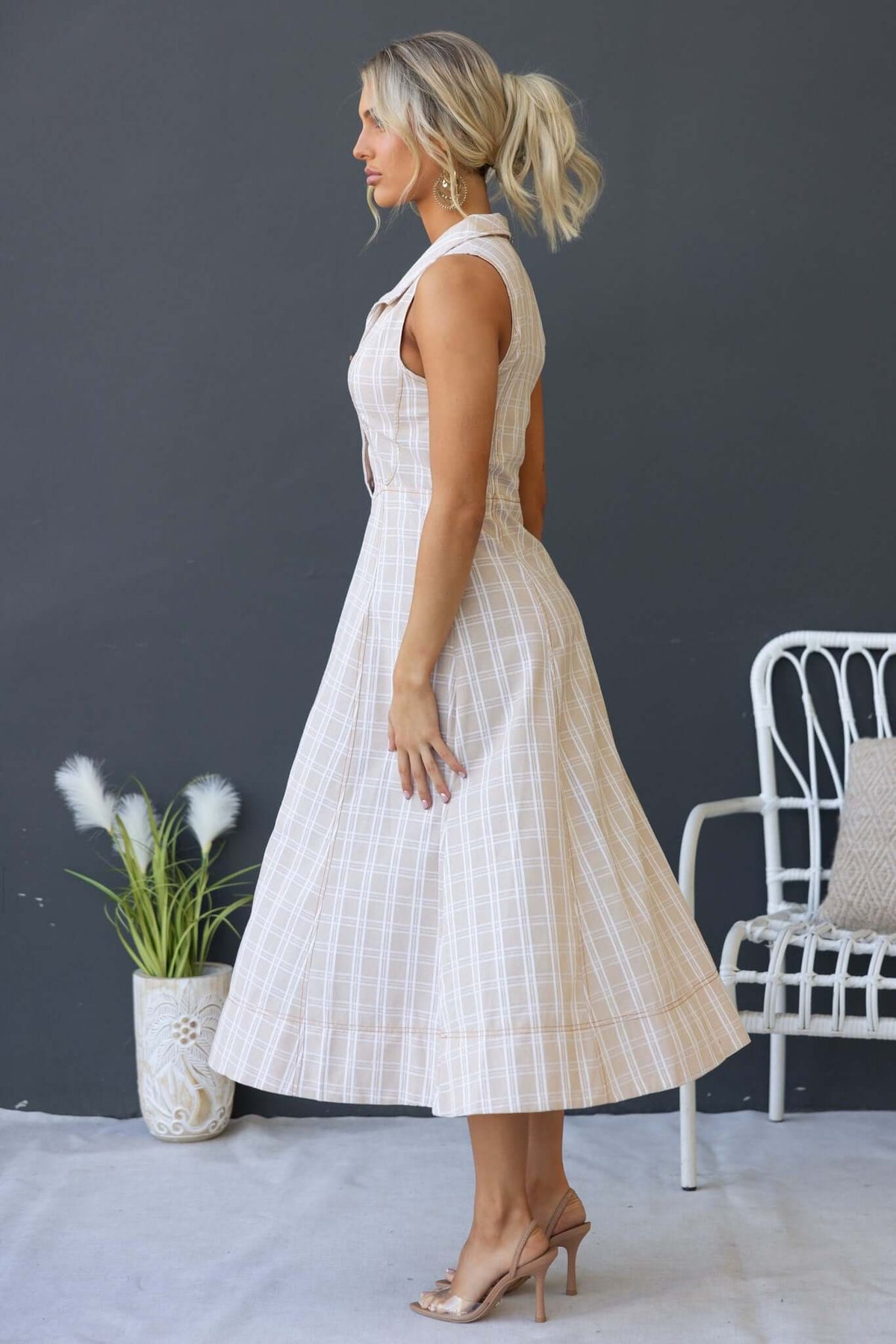 Side view of Harloh Midi Dress featuring a collar, button-up bust, and linen texture, worn by a model.