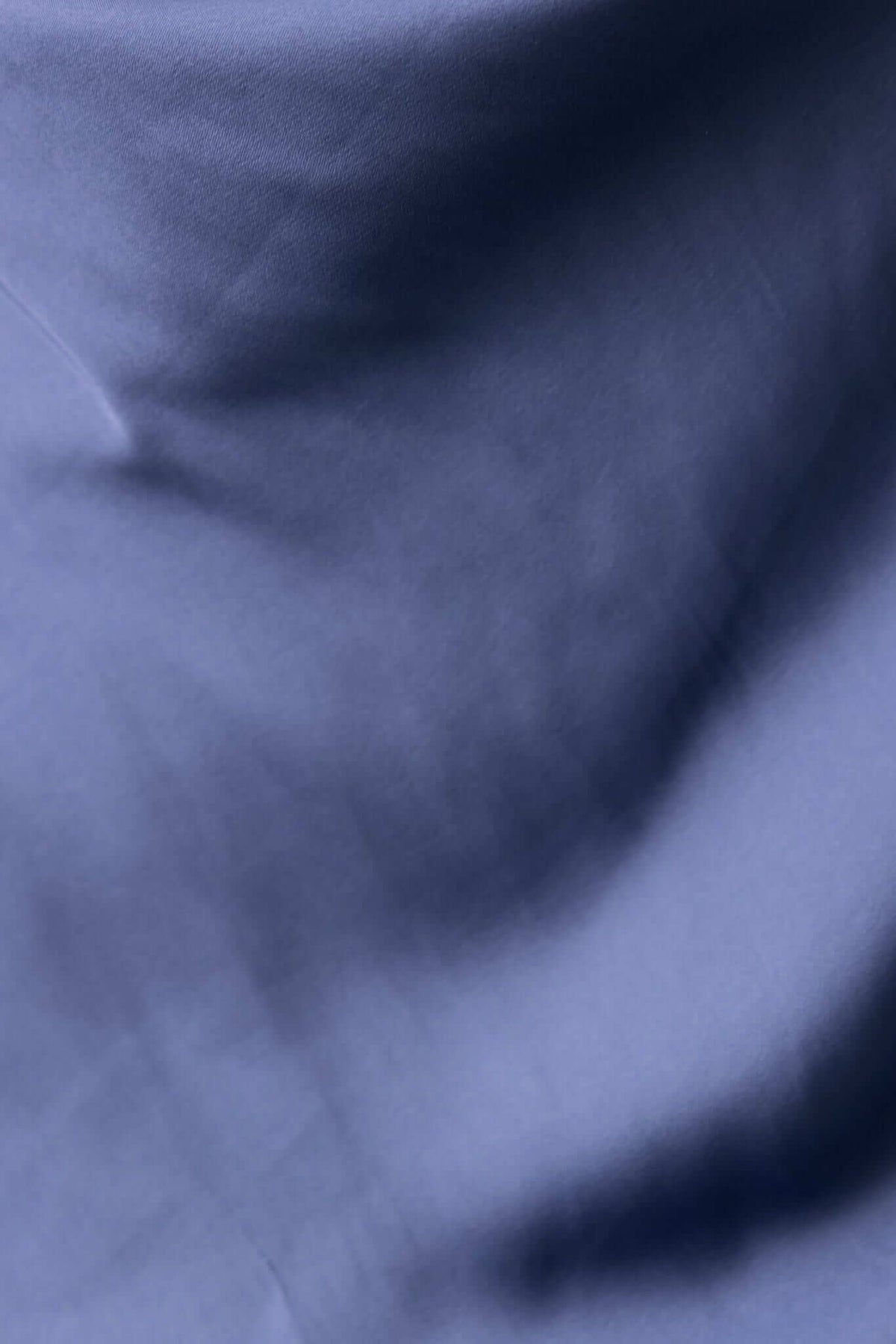 Close-up of smooth satin fabric texture in deep blue, highlighting its luxurious look and feel.