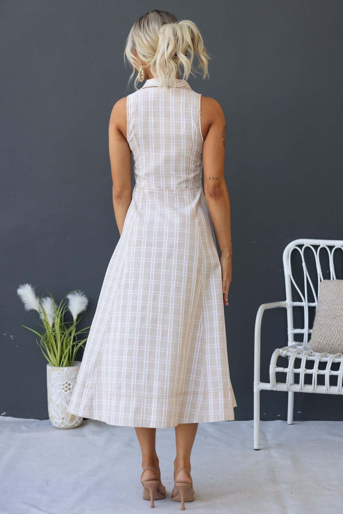 Back view of Harloh Midi Dress showcasing its collar, button-up design, and linen look with a plaid pattern.