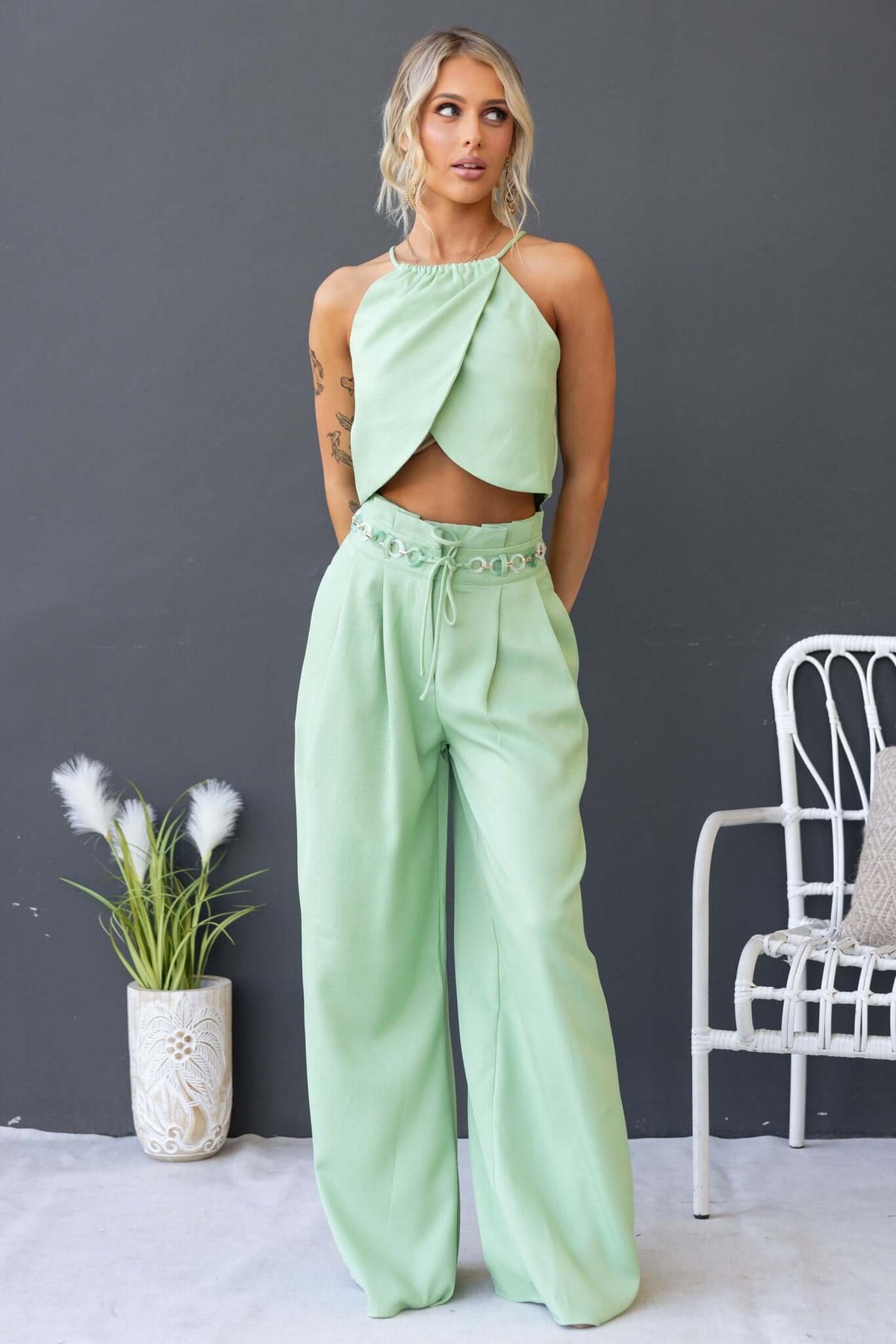 Model wearing Paytas Top with high neckline in mint green, paired with matching wide-leg pants.