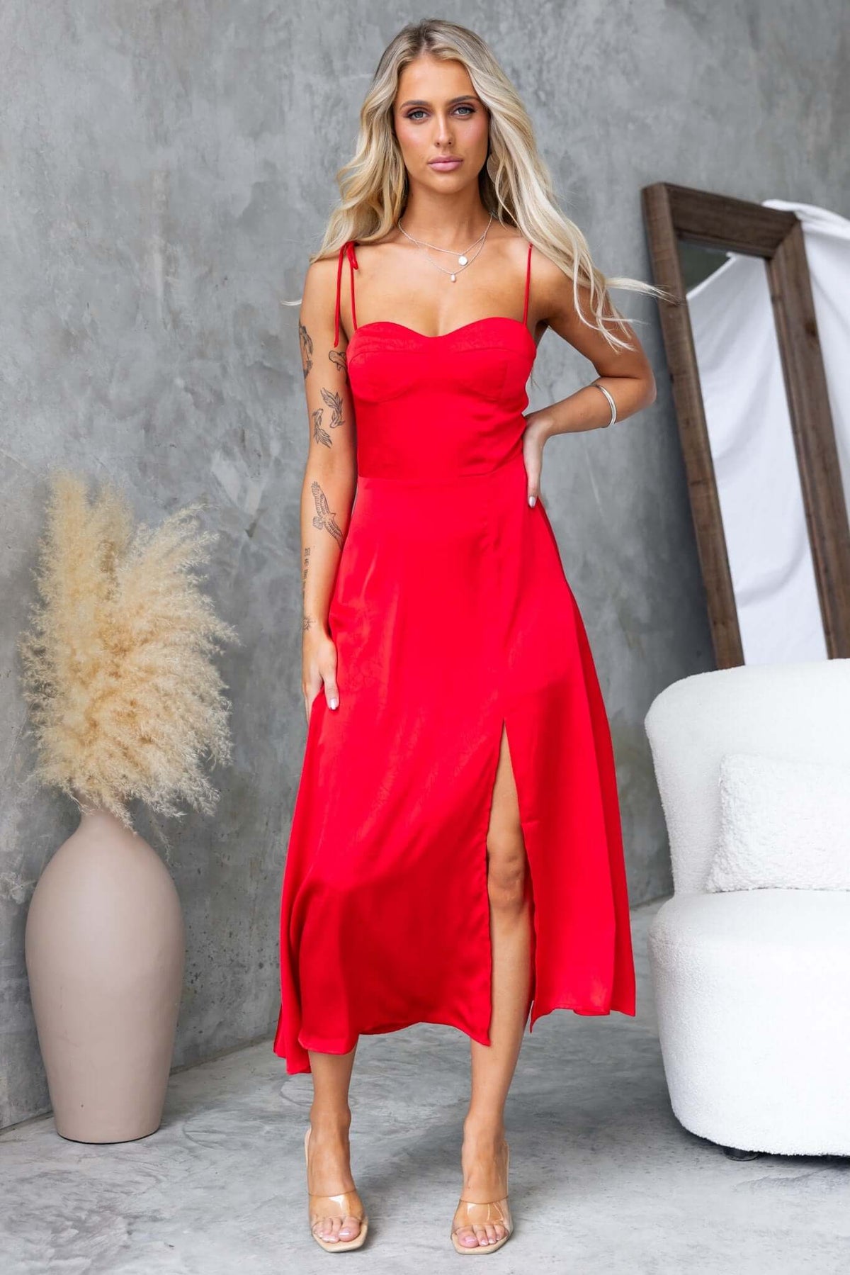 Elegant red maxi dress with adjustable spaghetti straps, featuring a front split and satin finish.