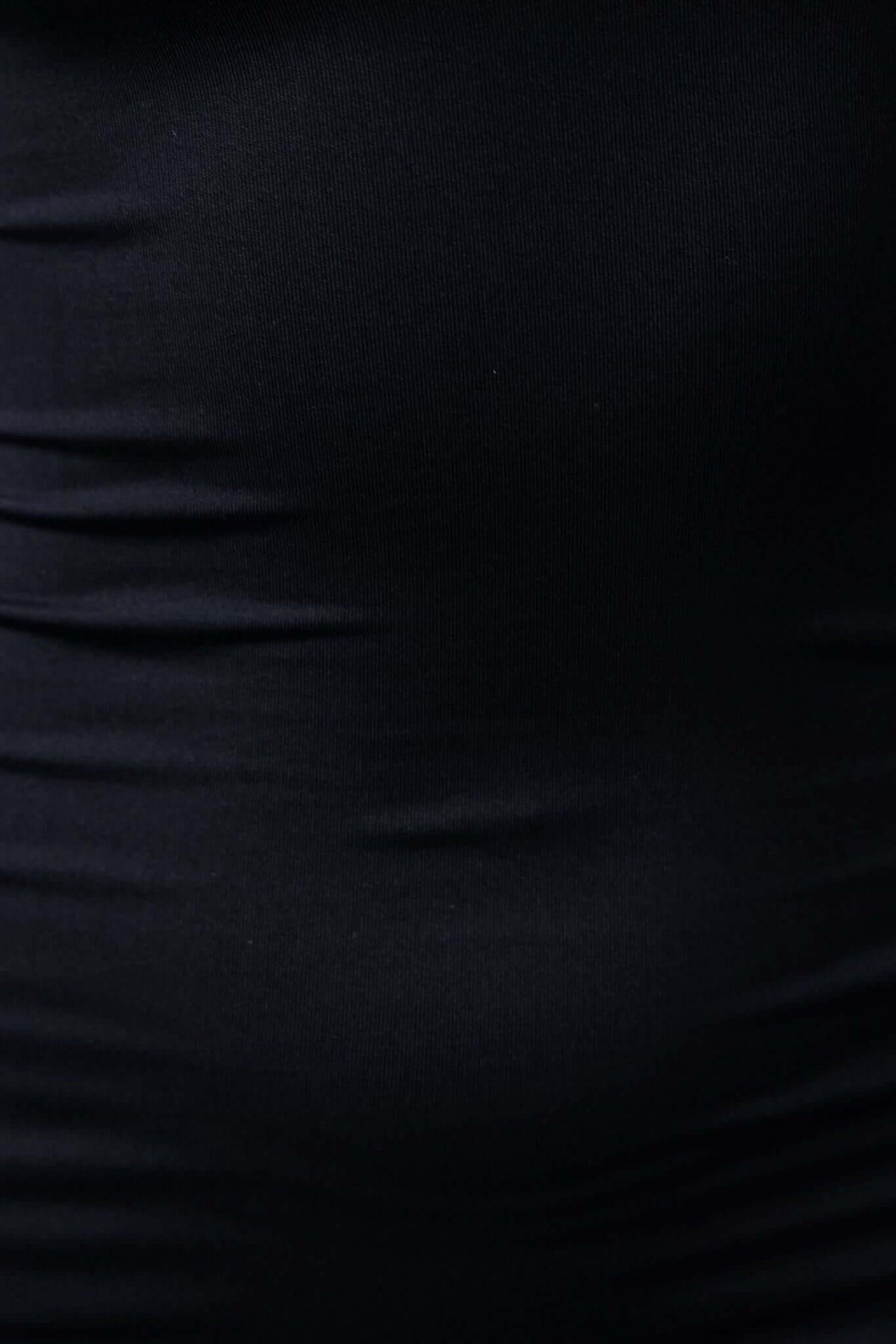 Close-up of black fabric showcasing the soft texture and stretch of the Nalfie Dress, perfect for a stylish look.