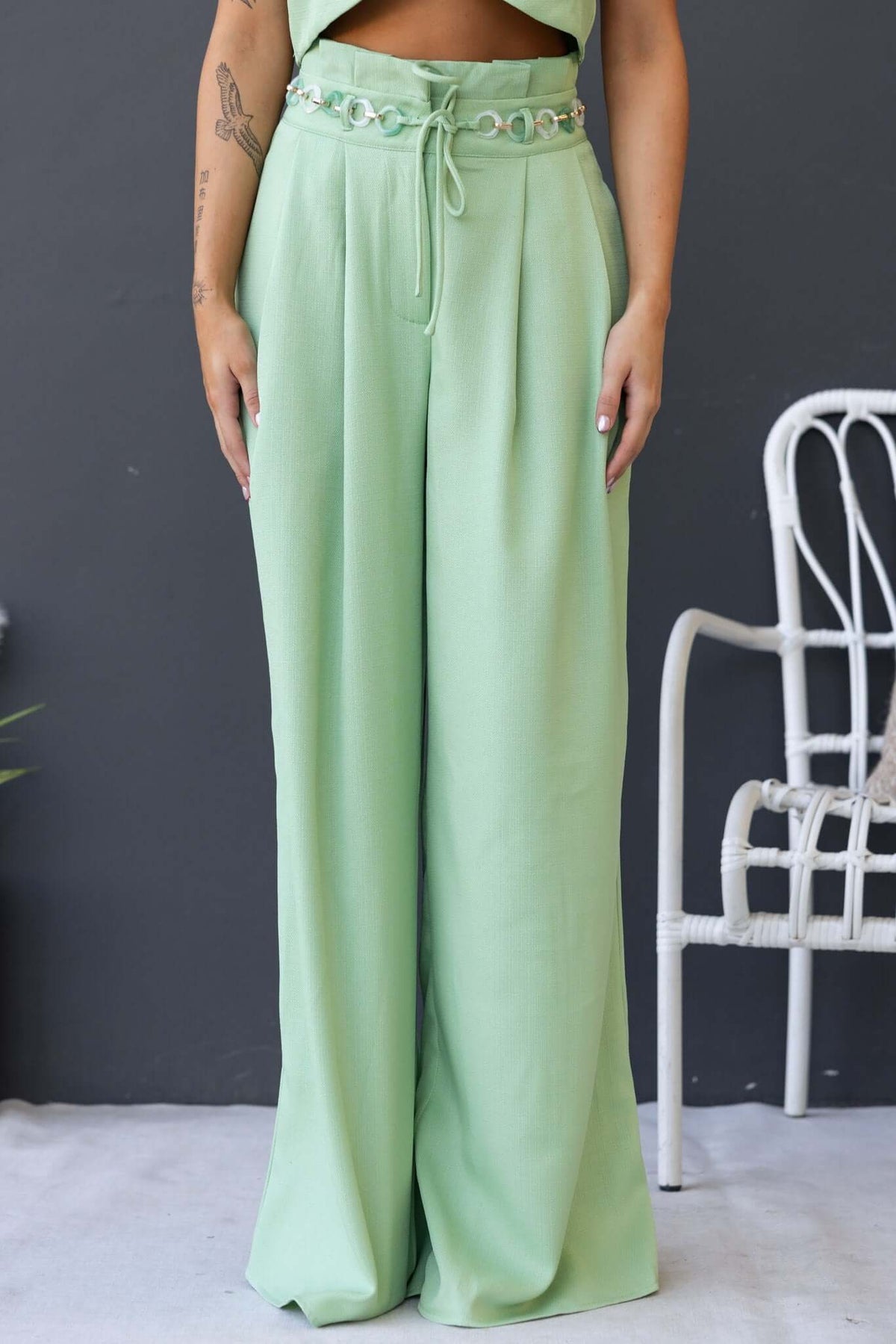 Light green Paytas Pants featuring a paperbag waist, removable belt, and front pockets for a stylish look.