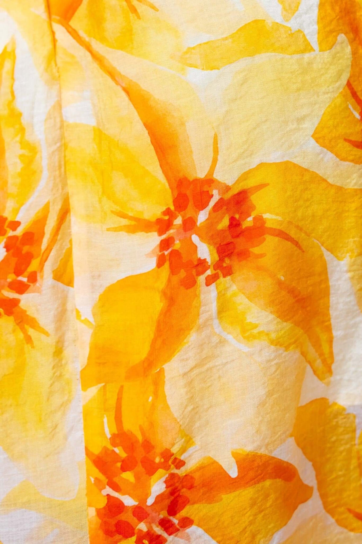Close-up of vibrant yellow and orange floral print fabric, perfect for a summer maxi dress.