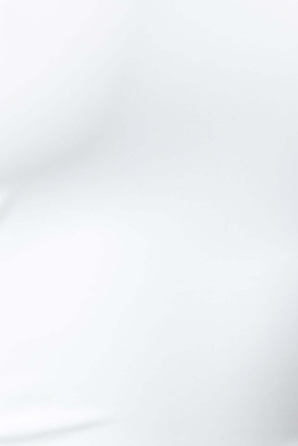 Close-up of white Orli Top featuring adjustable straps and stretchy material, ideal for casual outfits.