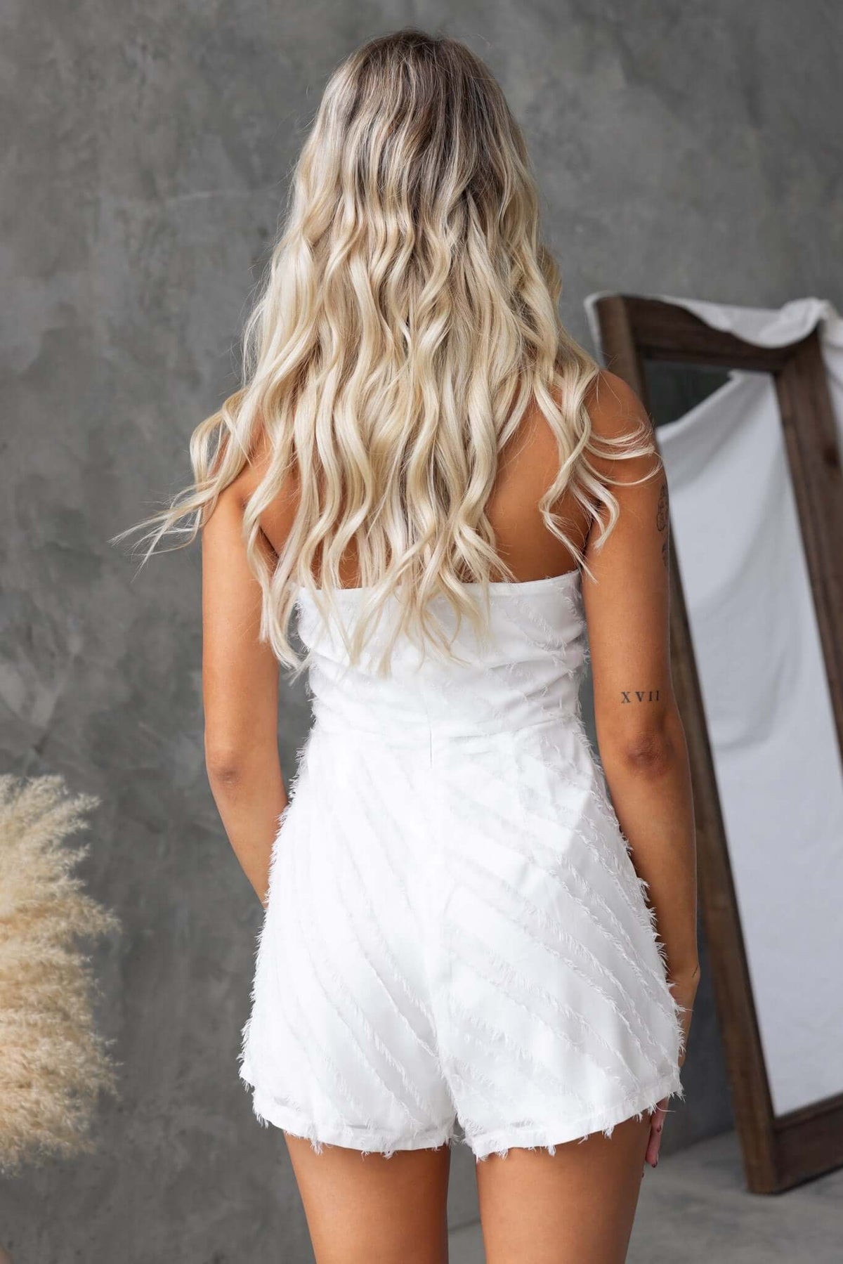 Back view of the Bossier Playsuit, featuring a strapless design and textured material.