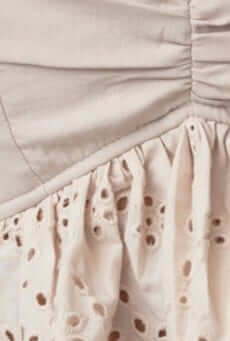 Close-up of Adams Top featuring adjustable straps and embroidered detailing on fabric.