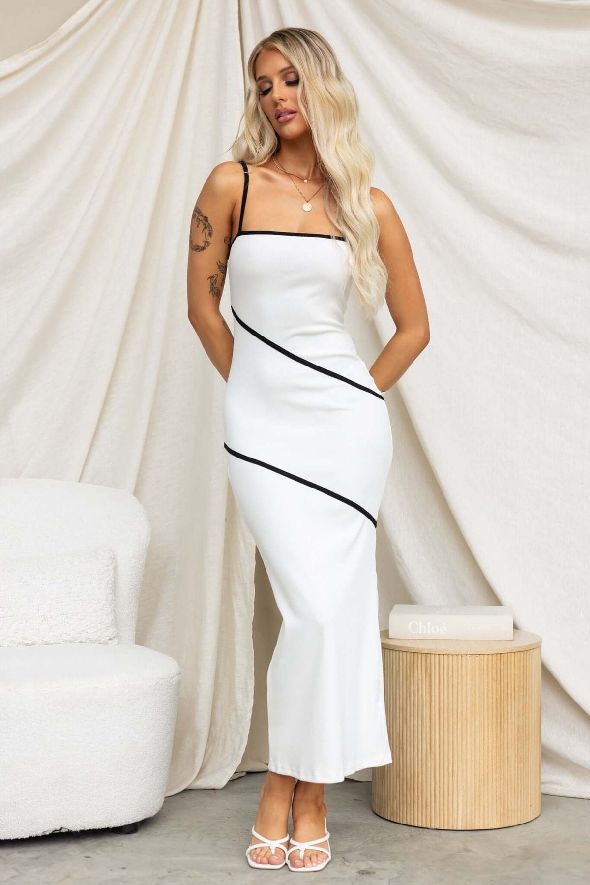 Elegant Flossie Maxi Dress in white with black accents, featuring adjustable straps and a stylish fit.