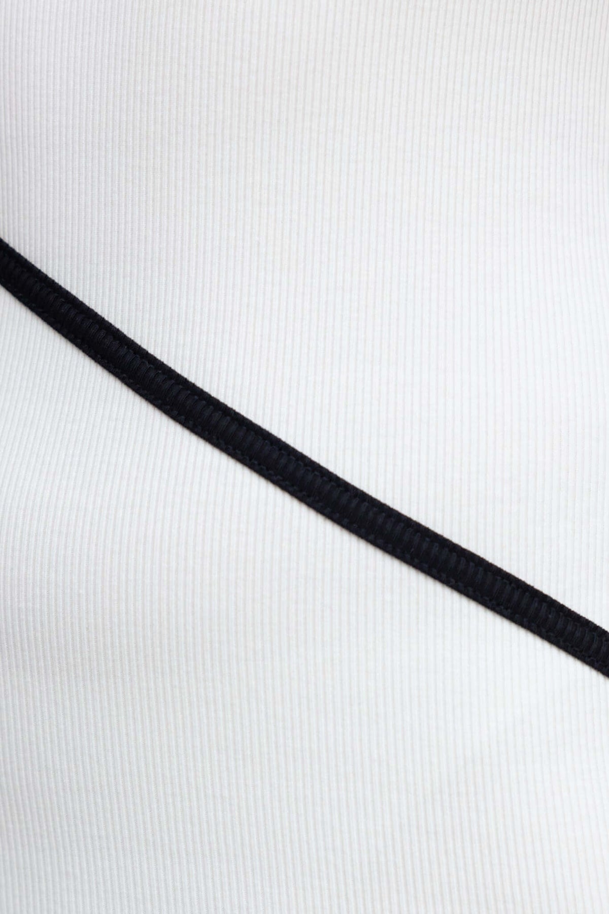 Close-up of ribbed fabric details featuring a black ribbon on white material of Flossie Maxi Dress.