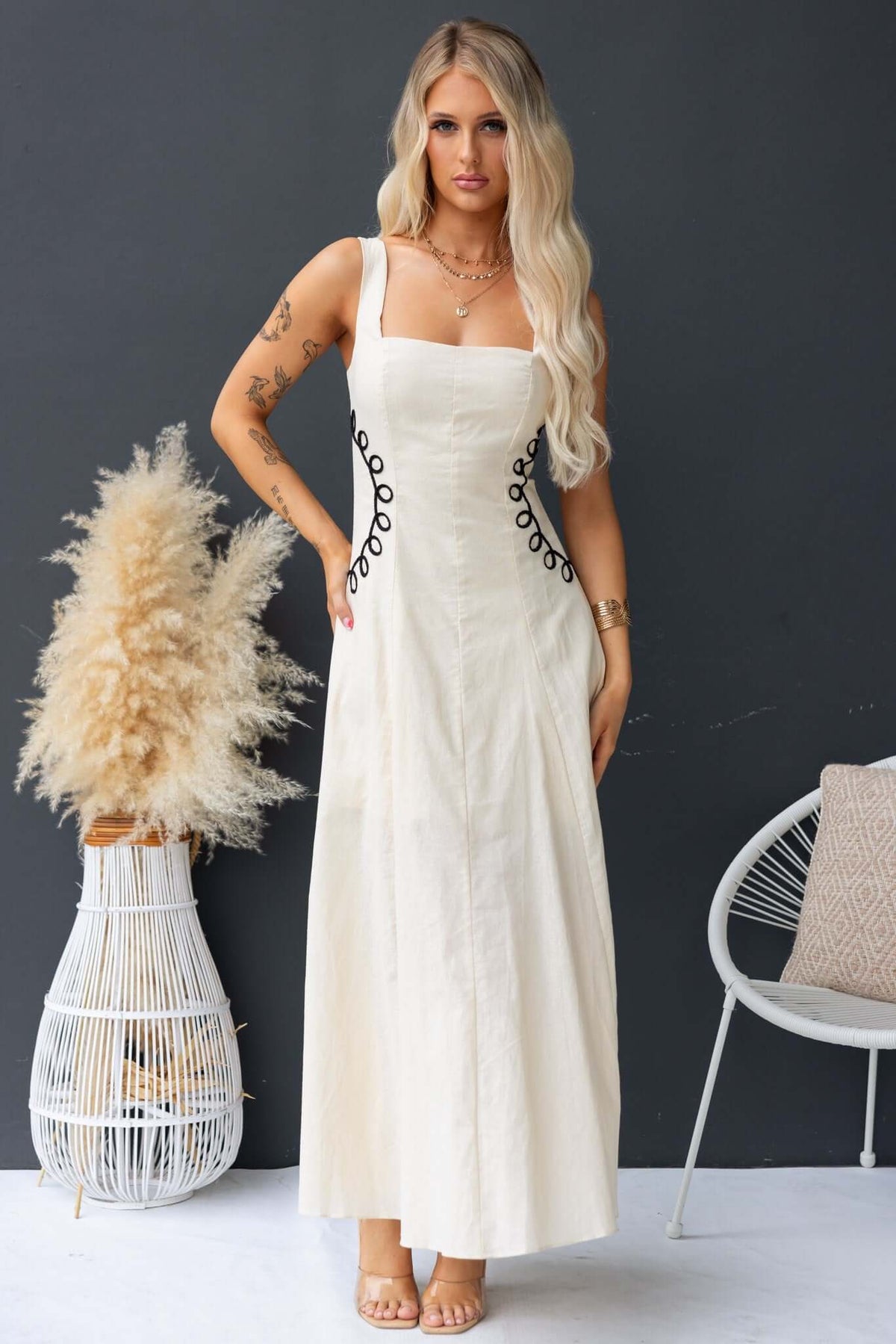 Huckle Maxi Dress featuring a model wearing a stylish linen blend dress with unique button detailing.