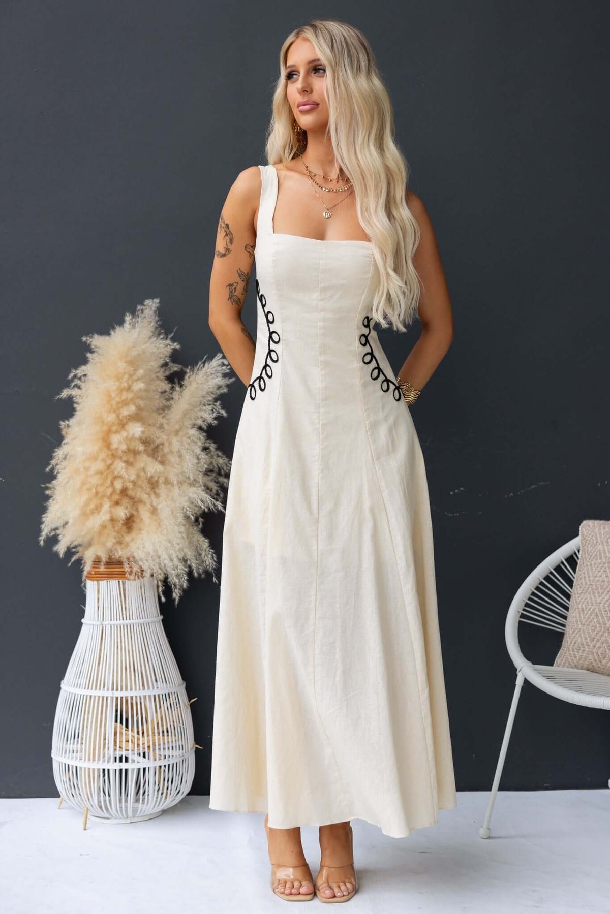 Huckle Maxi Dress featuring a model in a cream-colored linen blend with button detailing, showcasing a stylish summer look.