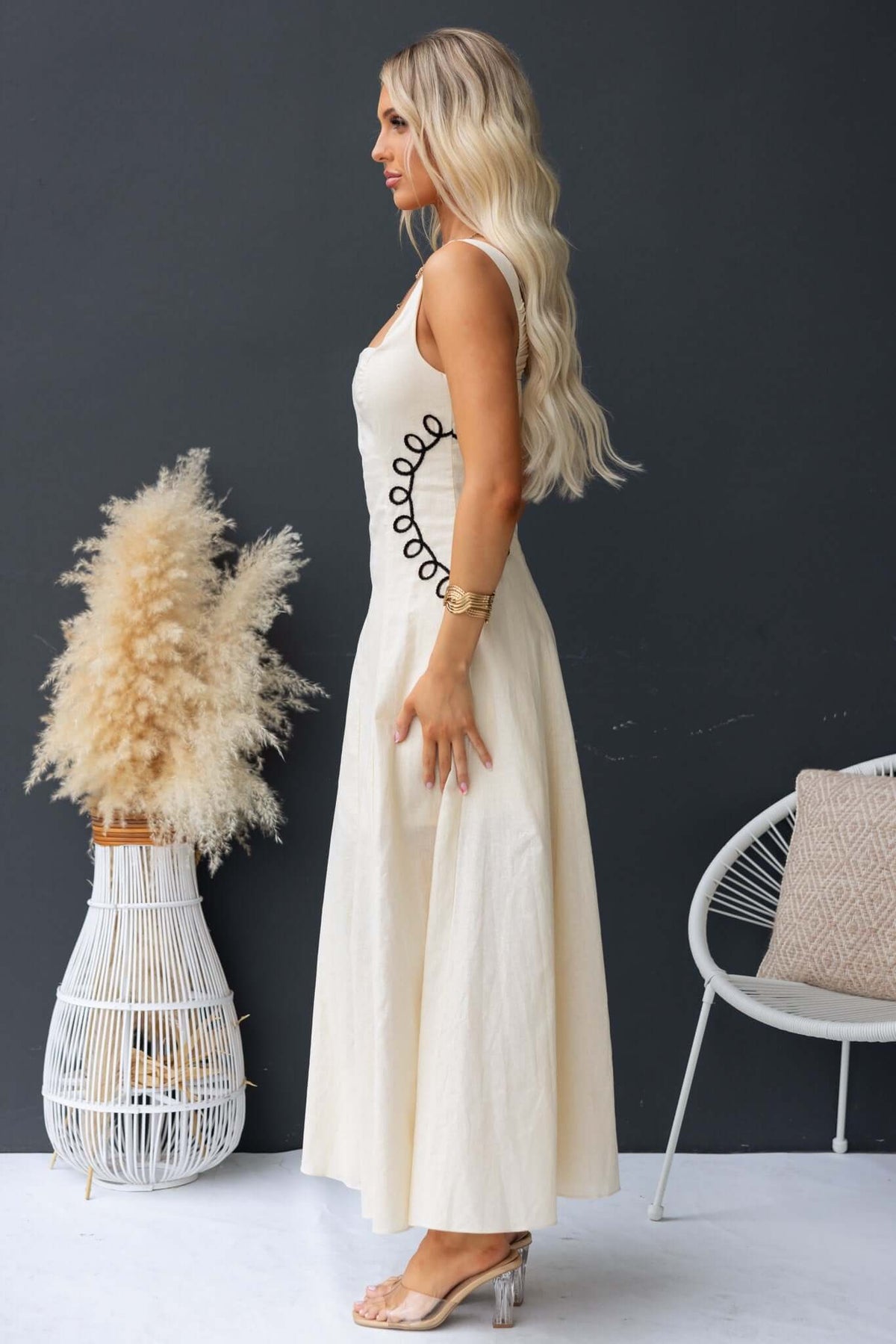 Side view of a woman wearing a Huckle Maxi Dress, showcasing its elastic back and stylish design.
