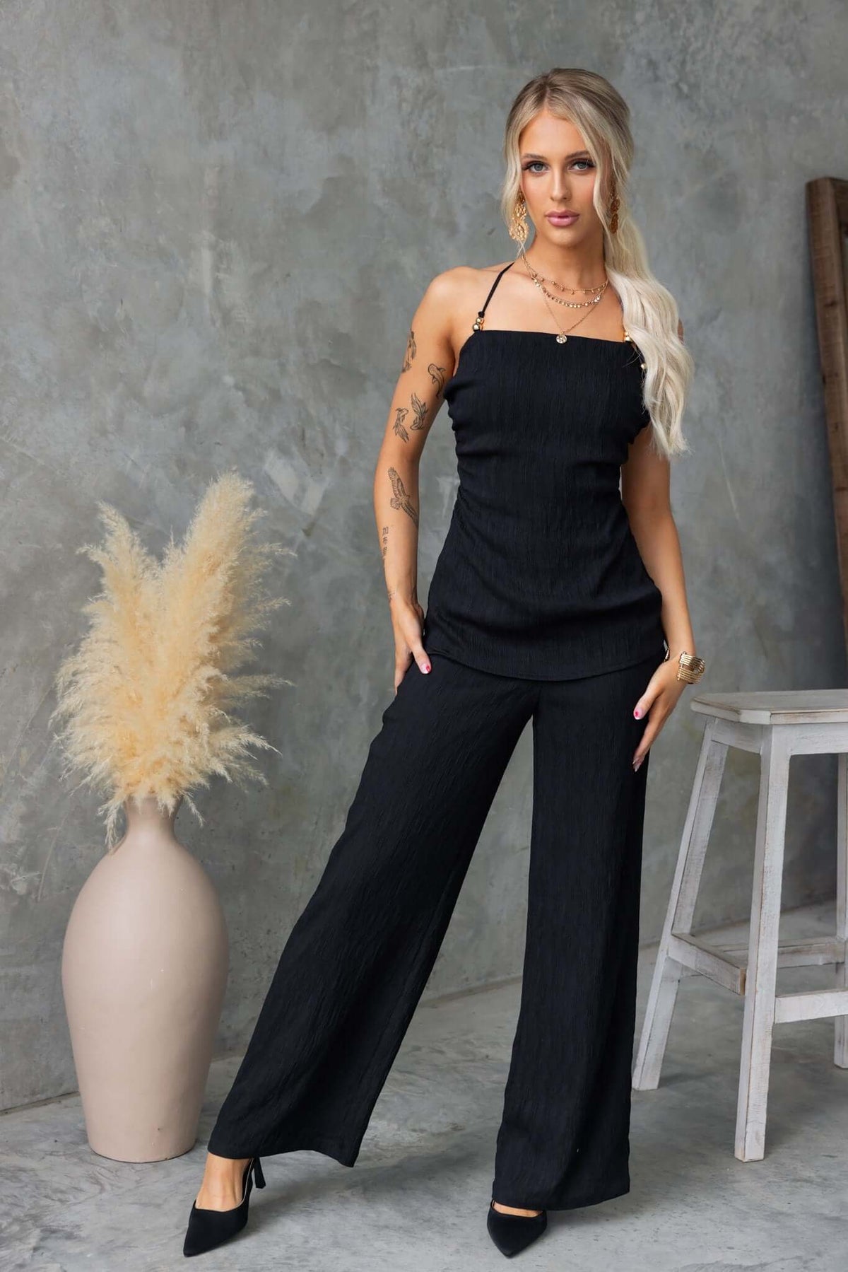 Model wearing Kayce Set in black, featuring a tie neckline top and mid-high waist pants, styled for a chic look.