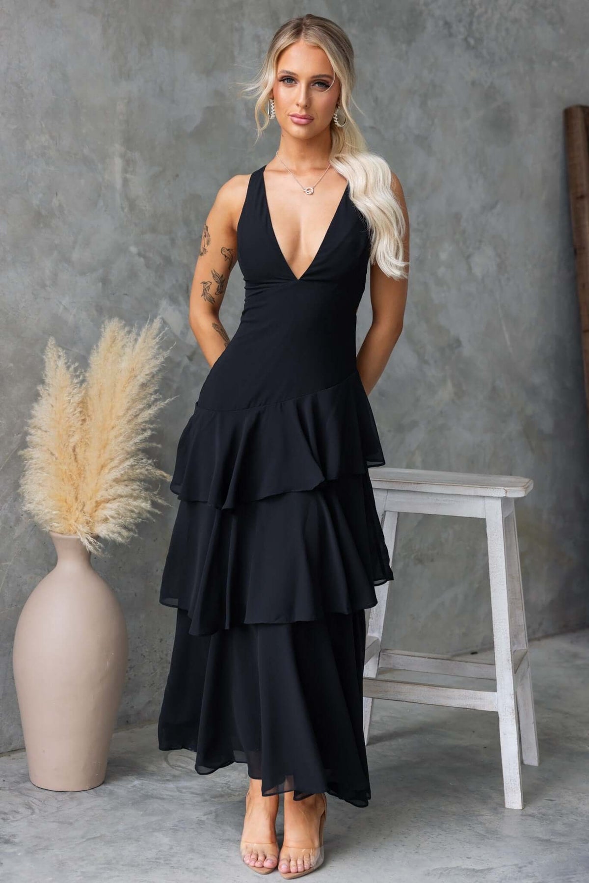 Elegant black maxi dress with V-neckline and multi-tier ruffle hem, perfect for formal occasions.