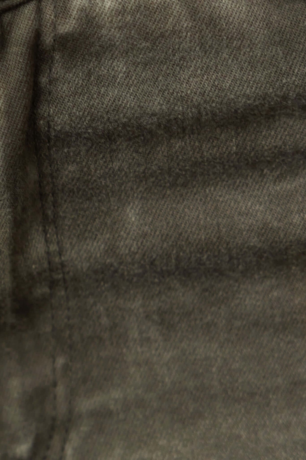 Close-up of fabric texture from Cassander Jeans with visible stitching and subtle patterns.