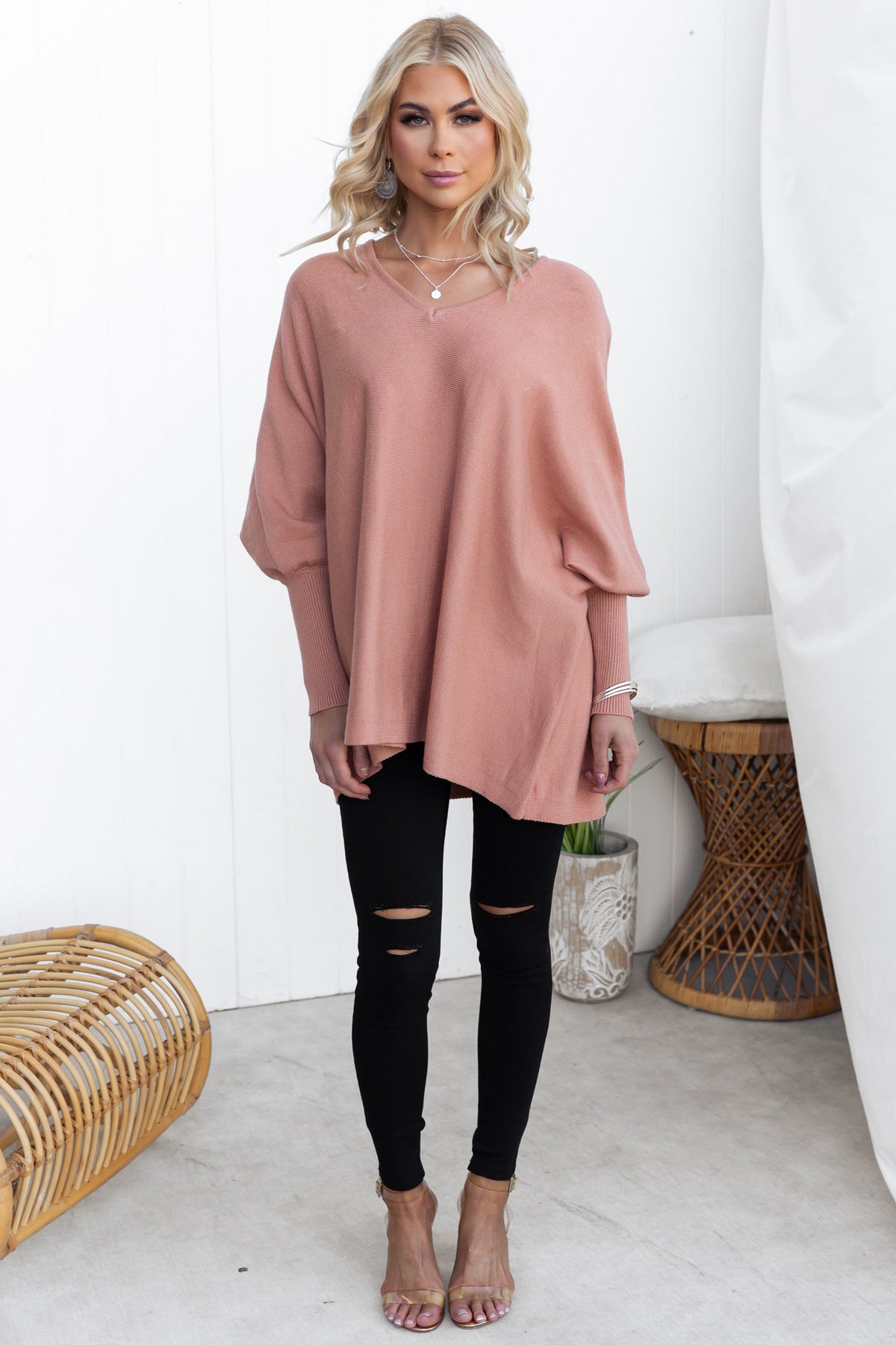 Brizzie Jumper in soft pink, featuring a V-neckline and batwing sleeves, styled with black ripped jeans.