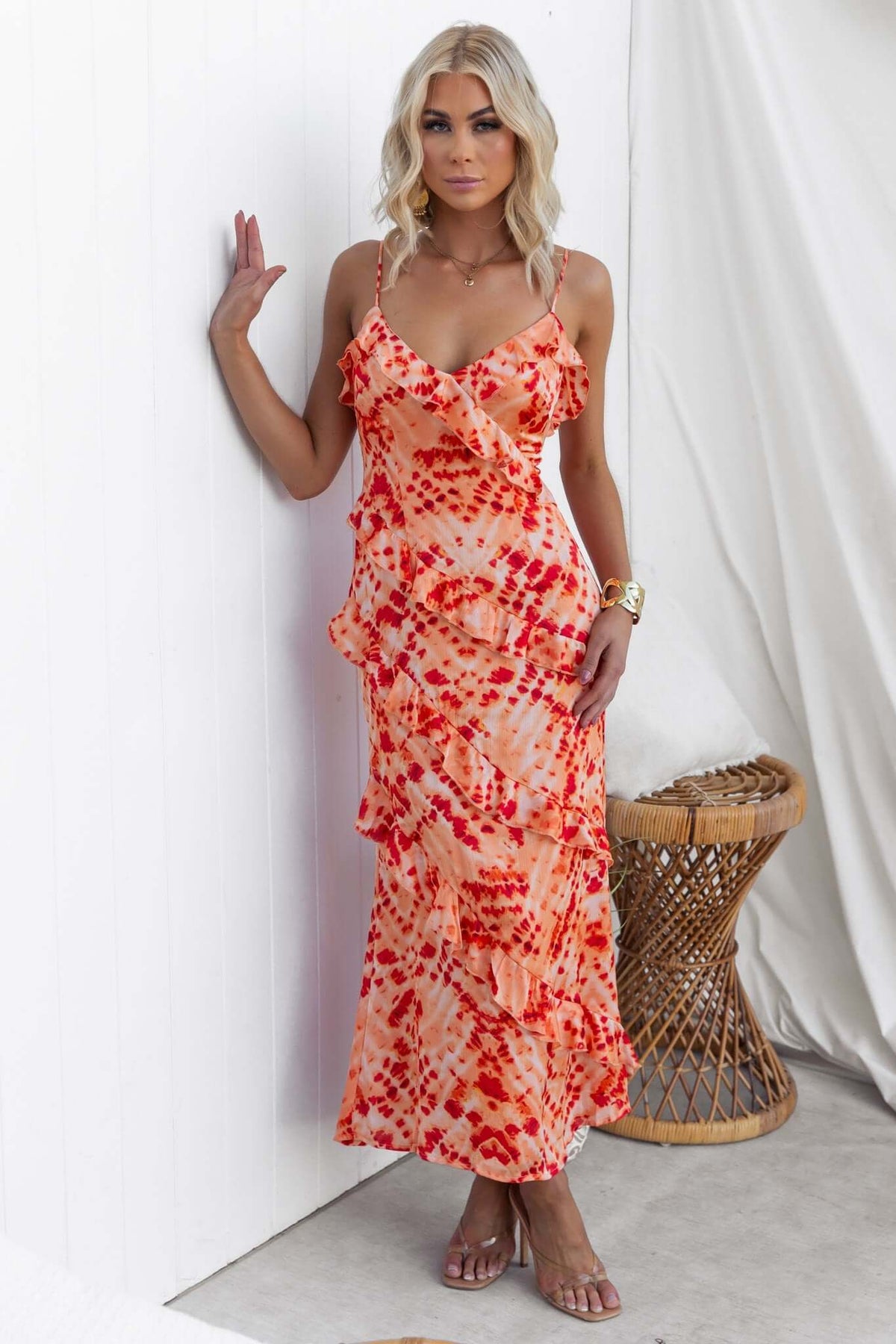 Model wearing an orange tie-dye Aquarius Maxi Dress with adjustable straps and ruffle detailing.