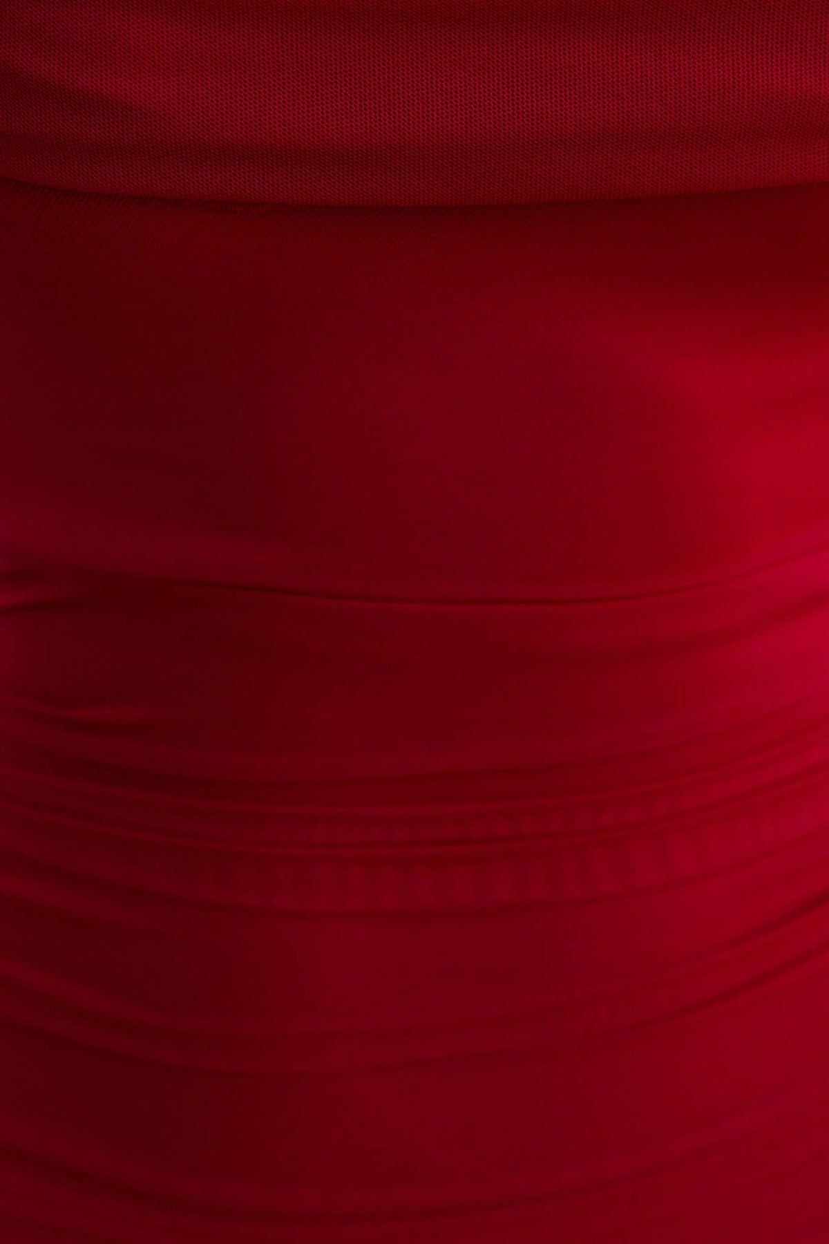 Close-up of the red mesh fabric of the Dorado Dress, showcasing a smooth, stretchy texture.