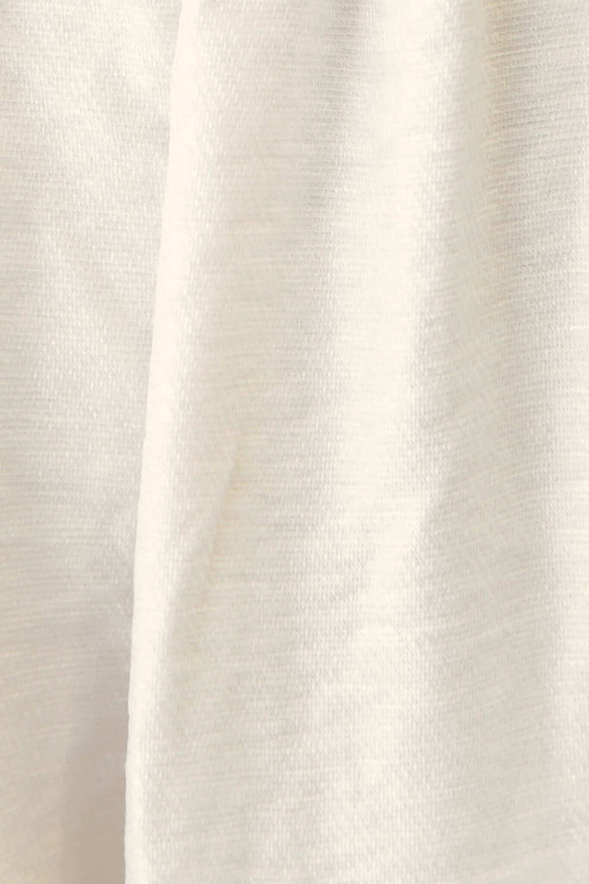 Close-up of soft, light fabric texture in an isabelline hue, ideal for a stylish midi dress.