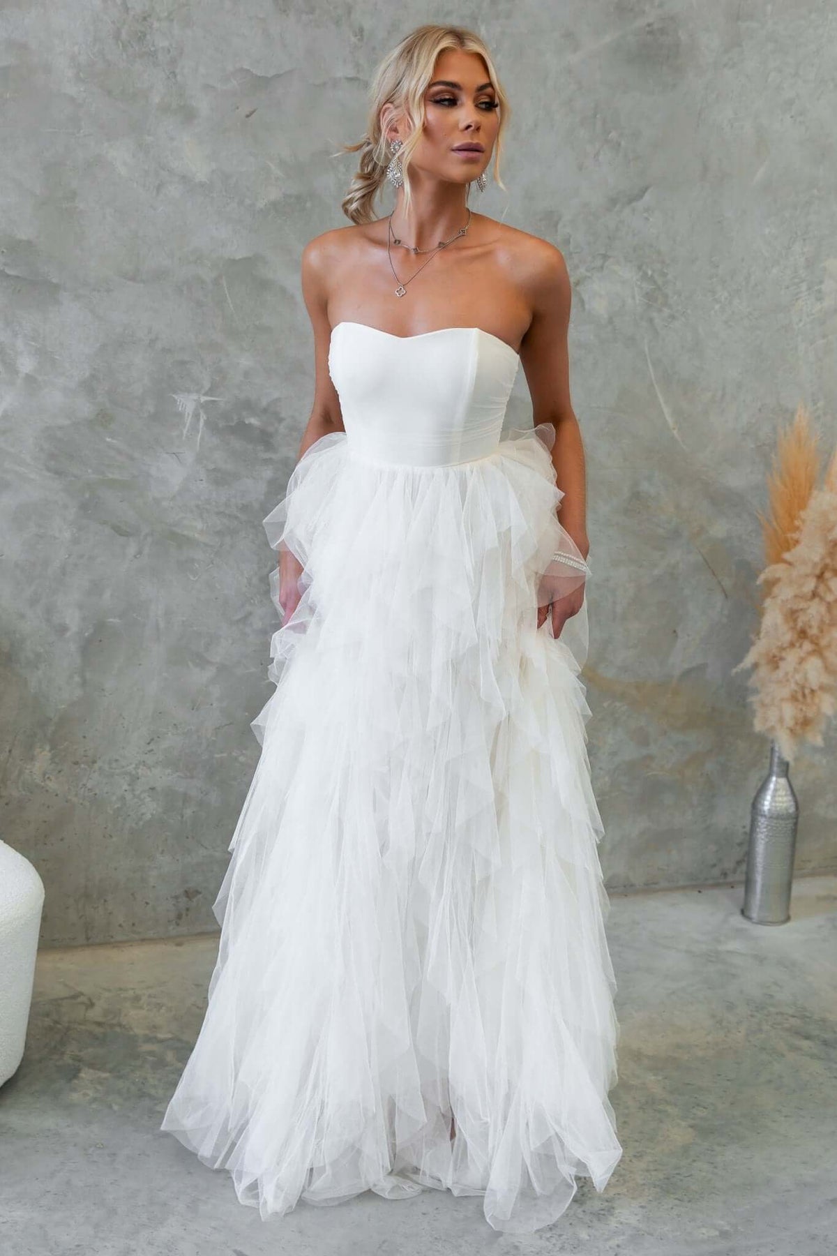 Strapless Carrie Maxi Dress with tulle overlay, featuring boning and an invisible zip, styled in a chic setting.