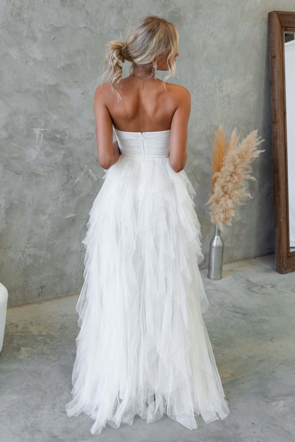 Back view of Carrie Maxi Dress with tulle overlay, strapless design, and boning details, showcased in a neutral setting.