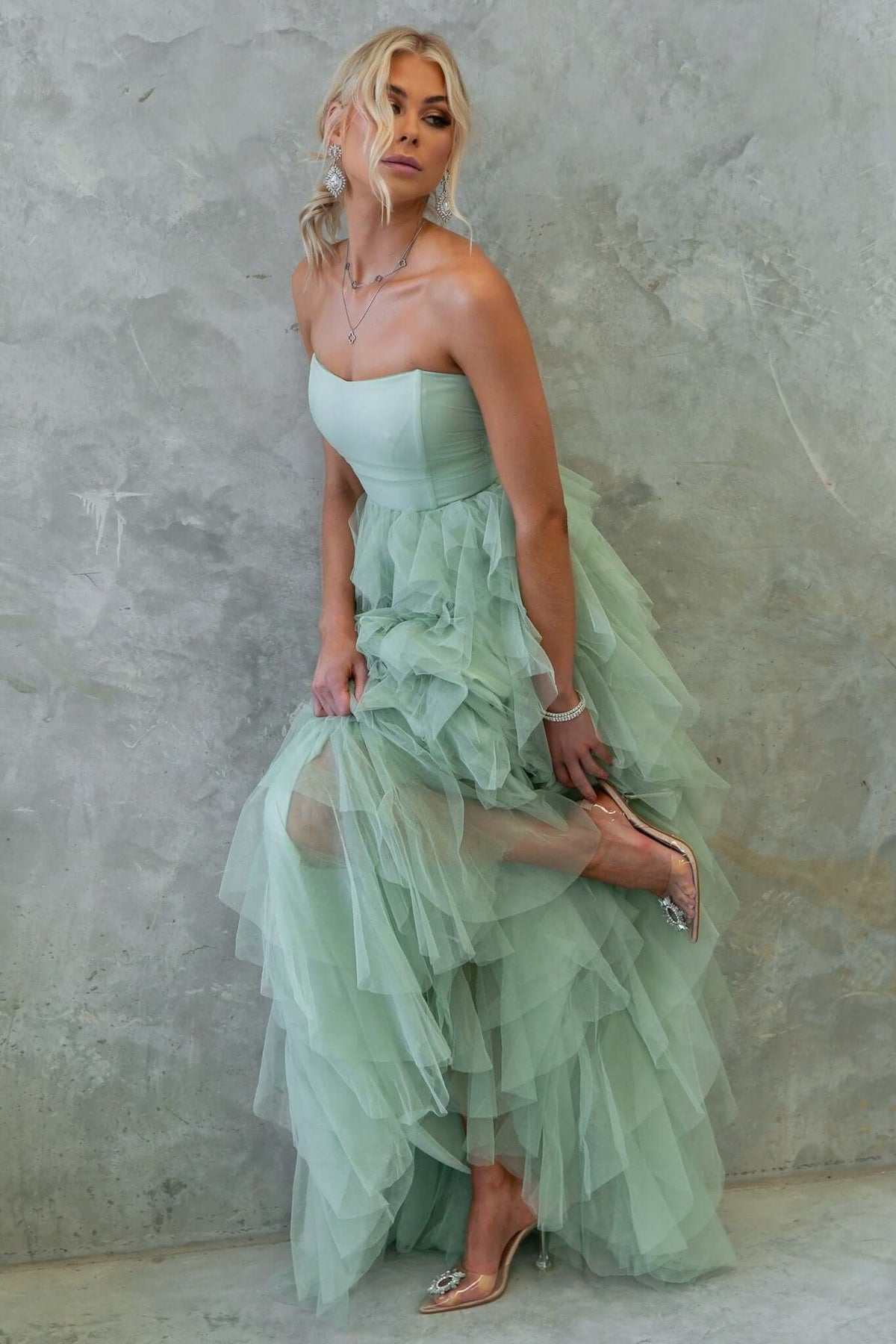 Carrie Maxi Dress in mint green, featuring a strapless design, tulle overlay, and layered ruffles on a model.