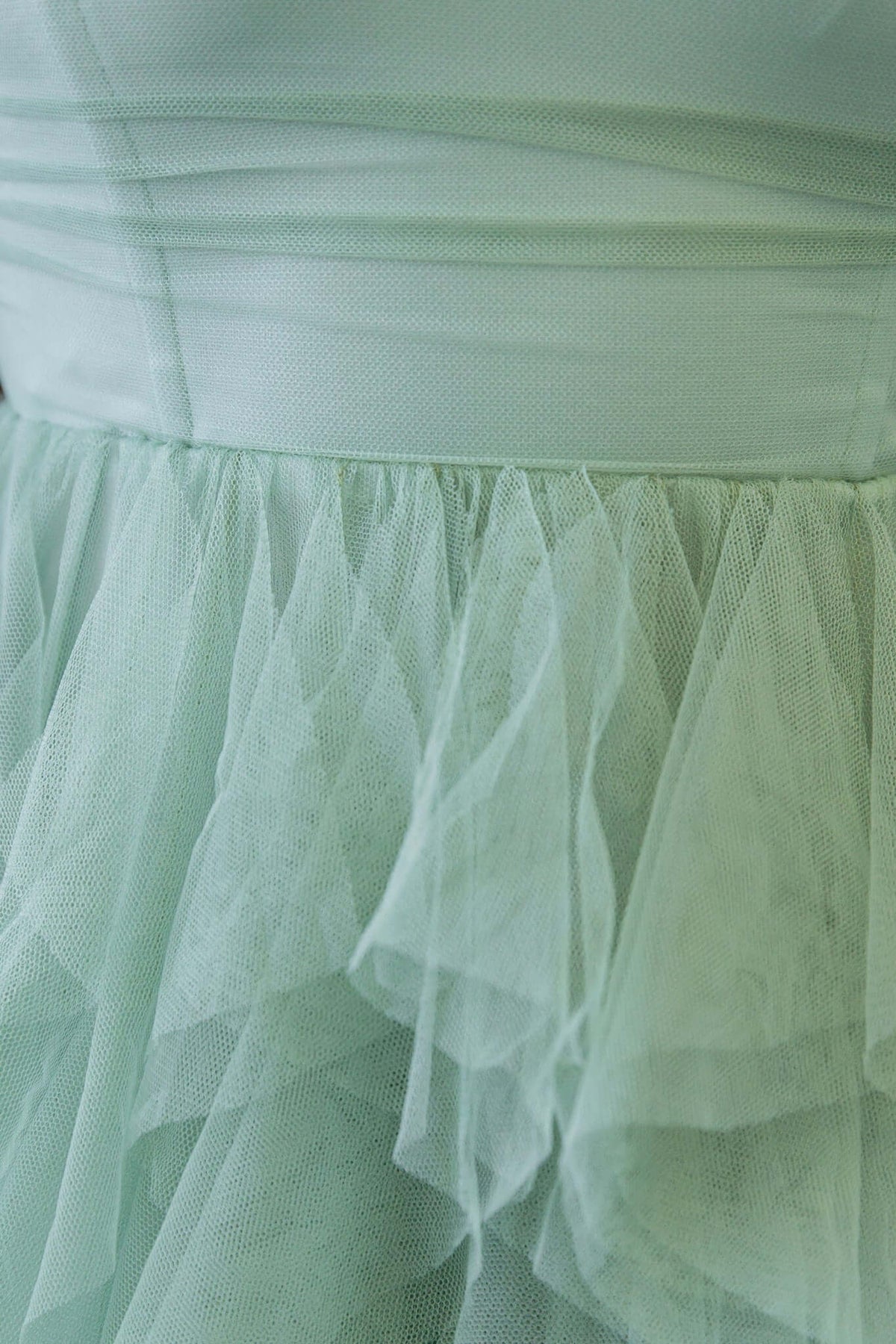 Close-up of a light green tulle overlay on the Carrie Maxi Dress, showcasing the soft layered fabric details.