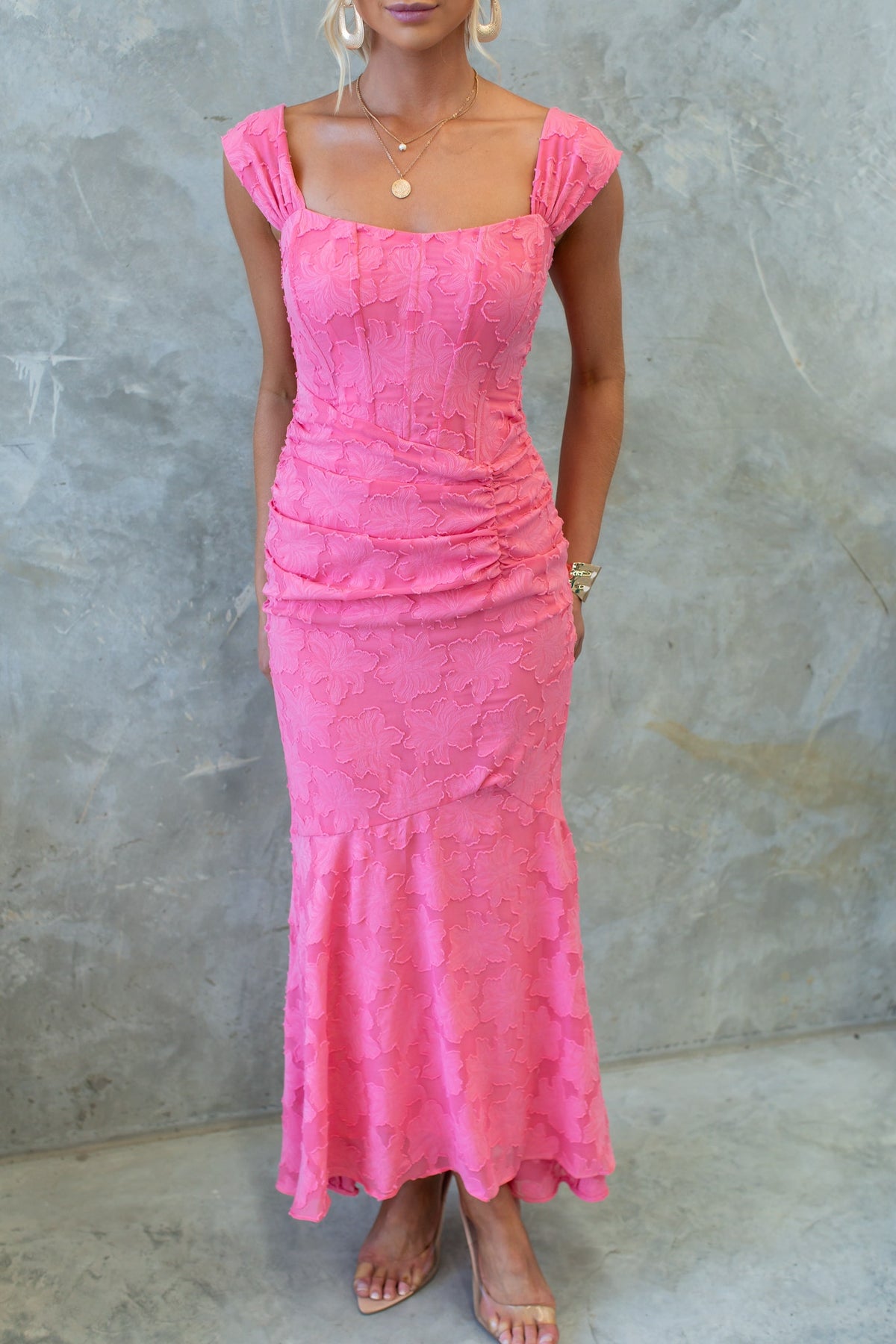 Model wearing a pink Arezzo Maxi Dress with boning, ruching, and textured details.