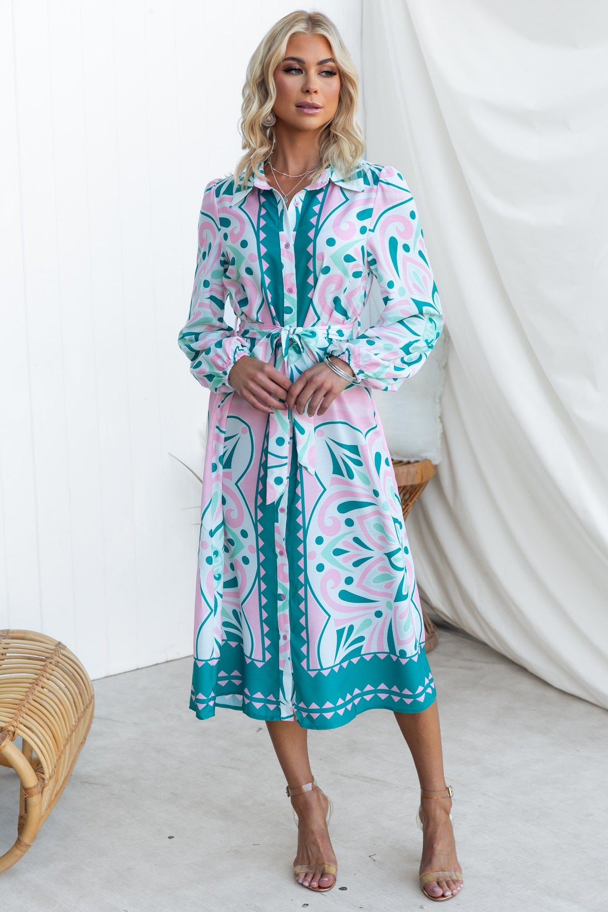 Elegant Faenza Midi Dress featuring a colorful floral design, button-up front, and removable tie, styled with heels.