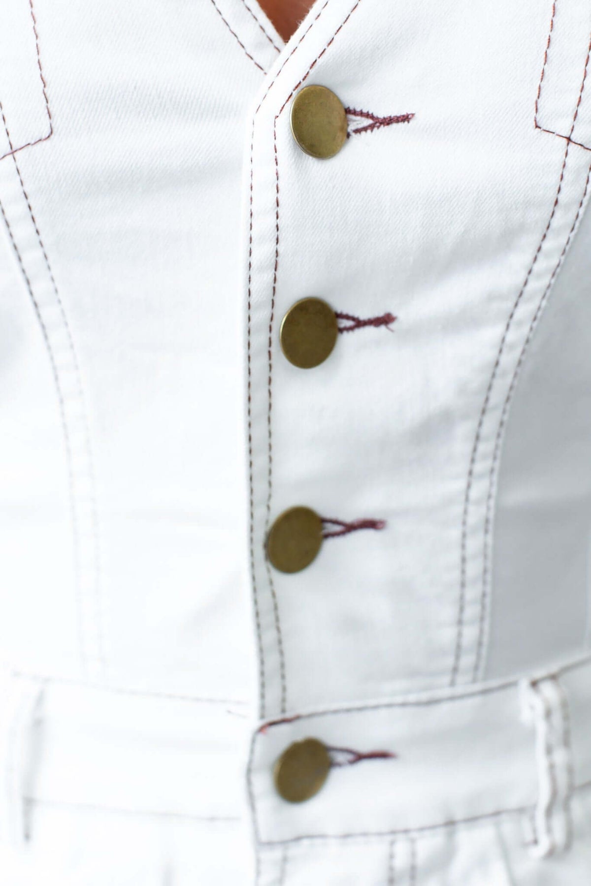 Close-up of Xenia Denim Playsuit featuring a V-neckline and button-up detail with gold buttons.