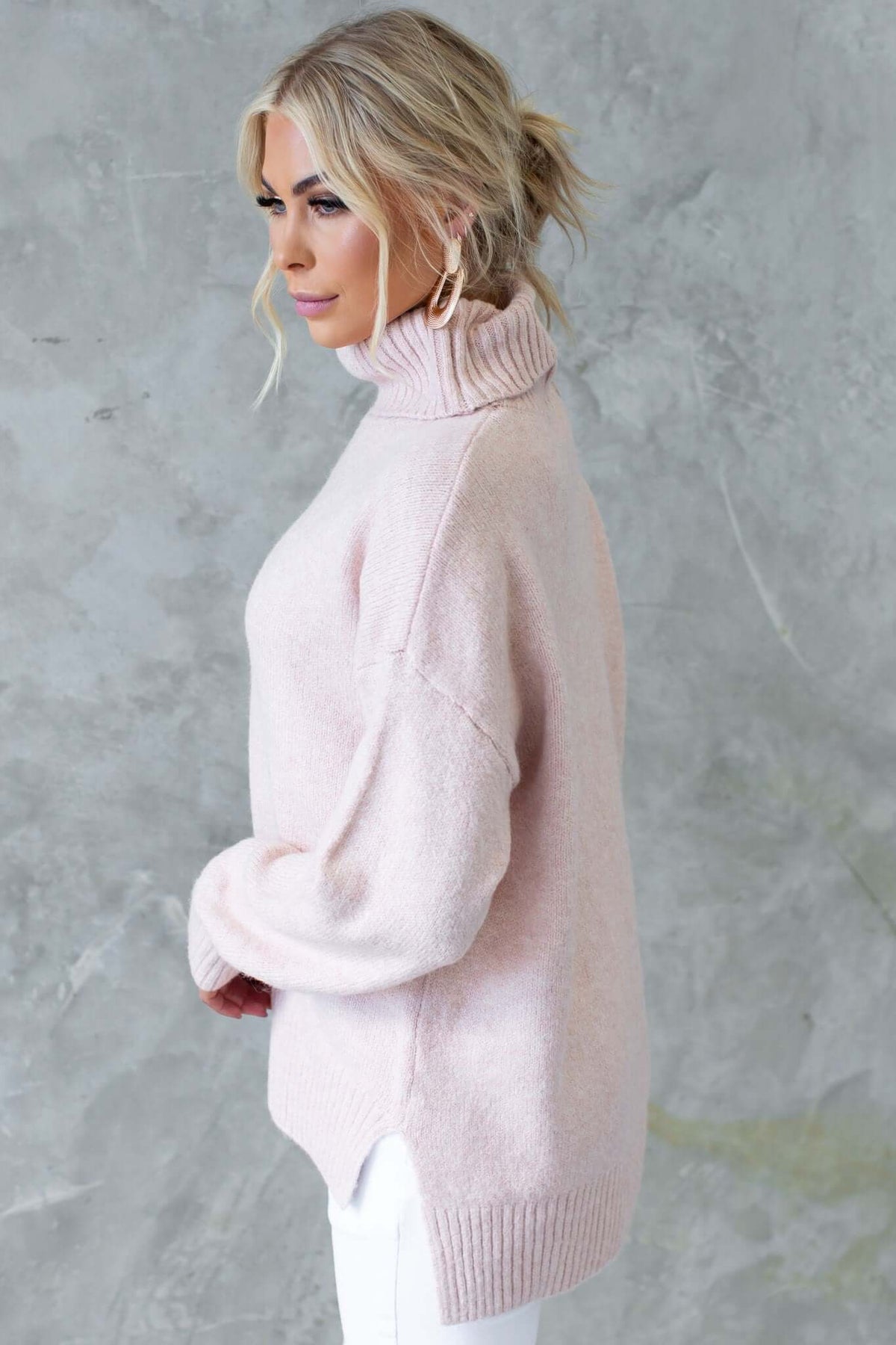 Orion Jumper in soft pink, ribbed knit, with turtle neckline and side splits, showcasing relaxed fit.