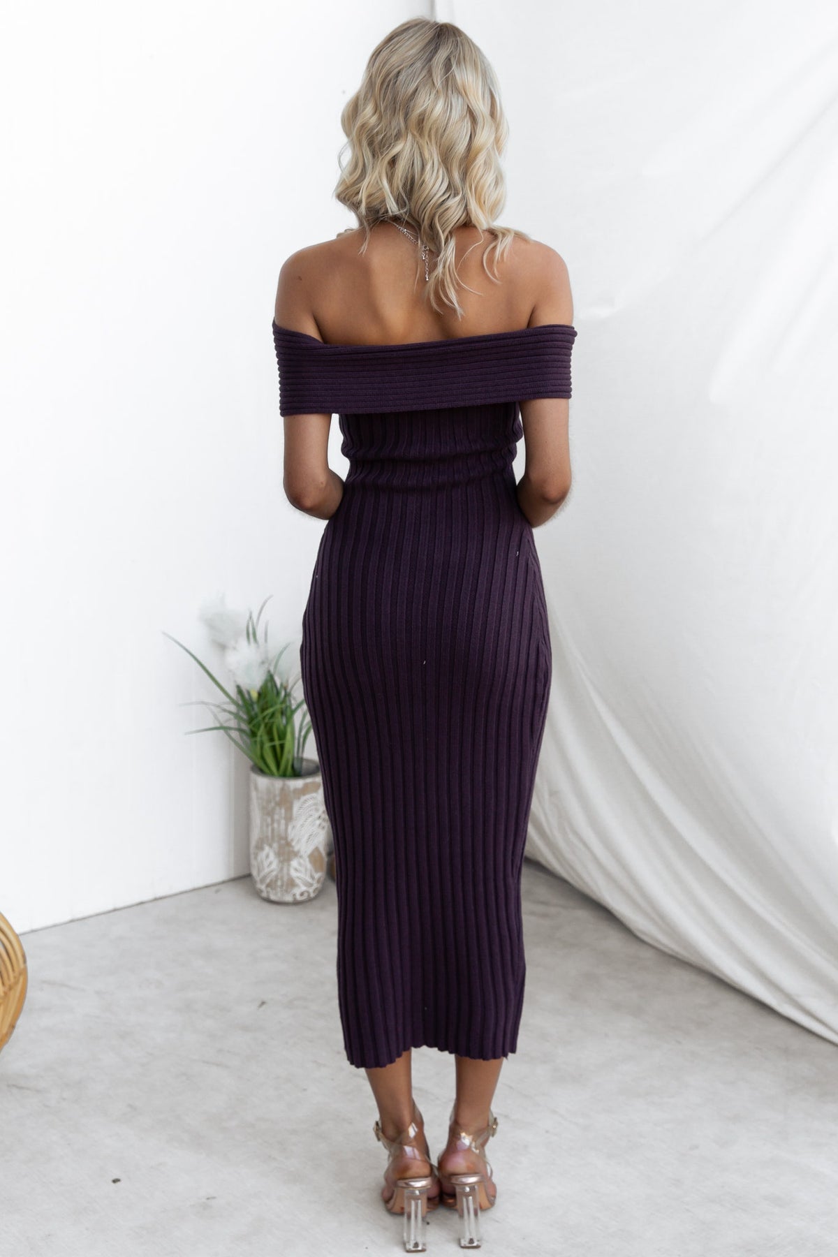 Back view of a woman in a ribbed knit off-shoulder Soulful Midi Dress in dark purple.