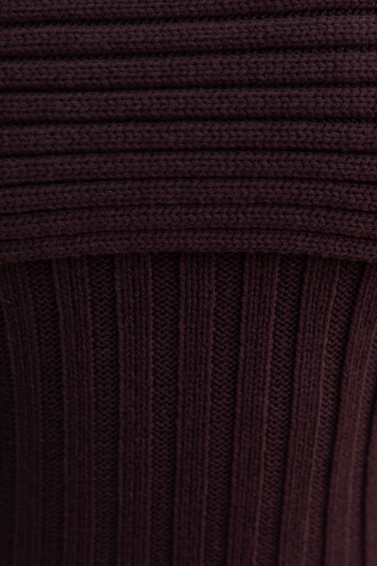 Close-up of ribbed knit material in dark brown, showcasing the stretchy texture ideal for a stylish midi dress.