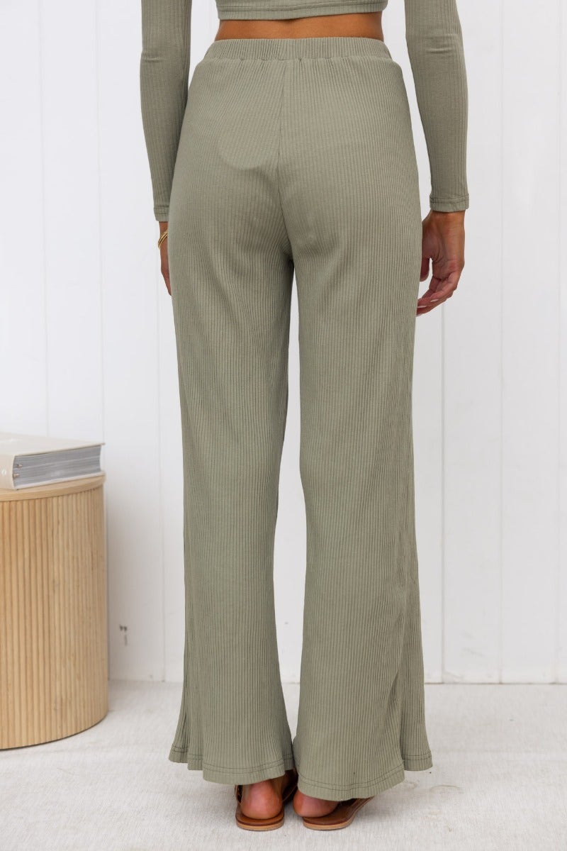 Back view of the Smitten Pants, featuring ribbed knit fabric, wide legs, and an elastic waistband in an olive color.