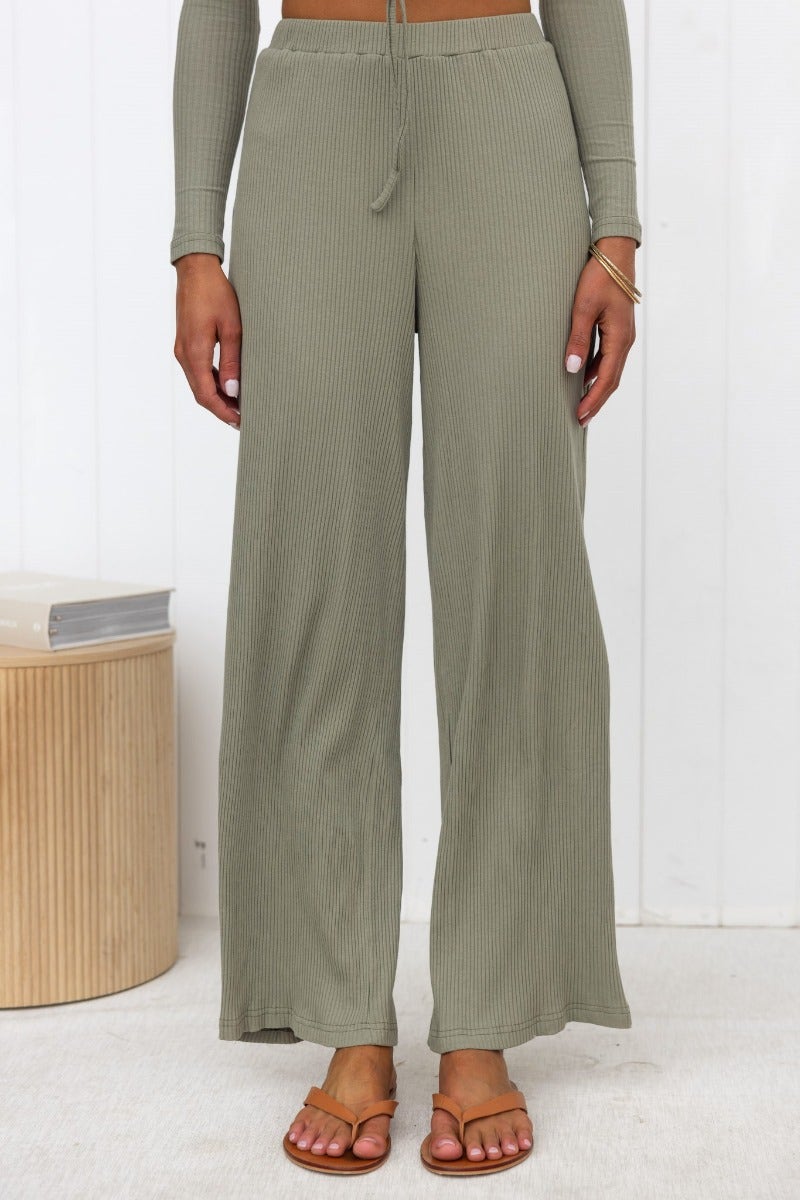 Model wearing olive ribbed knit Smitten Pants with wide legs and elastic waistband.