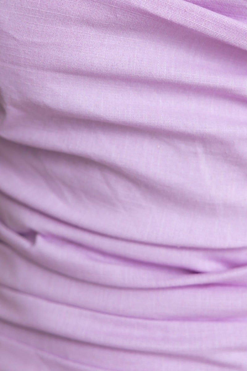 Close-up of soft lavender fabric showcasing delicate ruching and texture.
