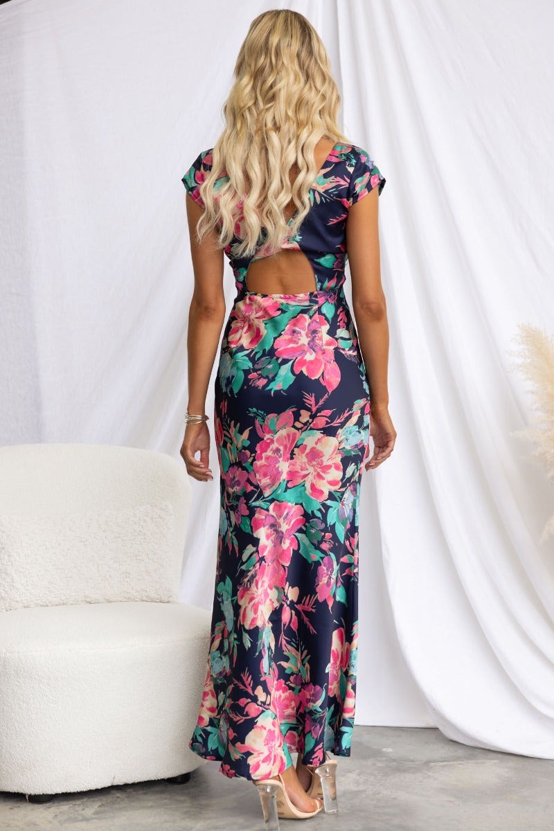 Back view of a navy floral print maxi dress featuring a V-neckline, cap sleeves, and cut-out detail.