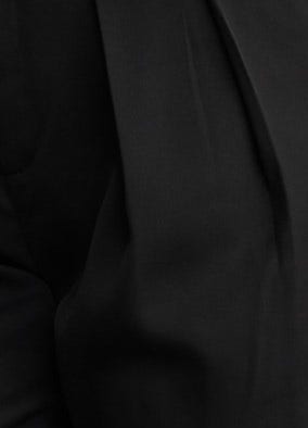 Close-up of the Tahni Pants fabric, showcasing the sleek black material and tailored details suitable for dressy occasions.
