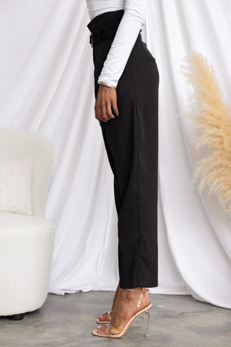 Side view of black Tahni pants featuring a mid-high waist and removable fabric belt, styled with a white top.