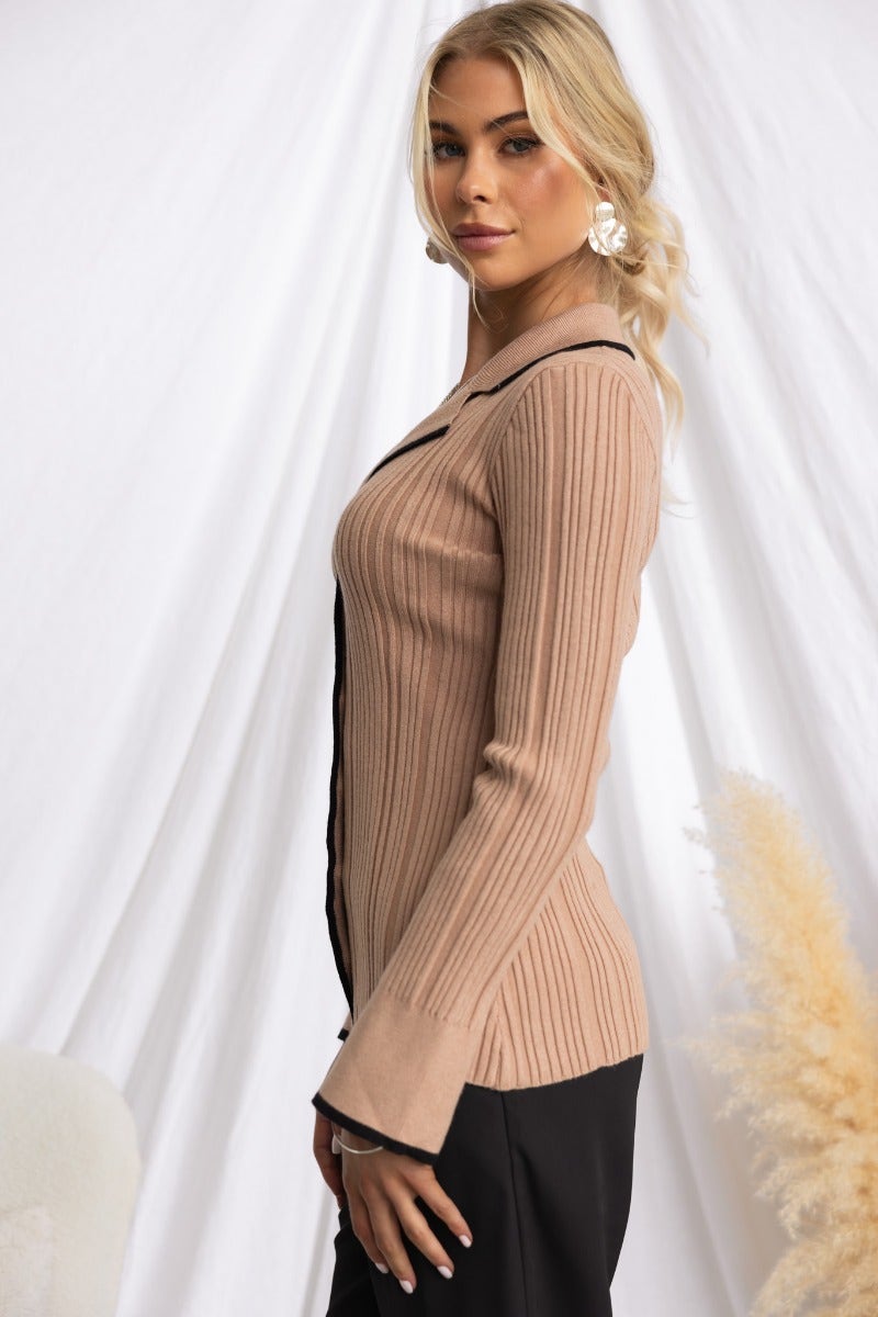 Side view of the stylish Shilah Top featuring ribbed knit, button-up front, and sleeve splits in a soft beige color.