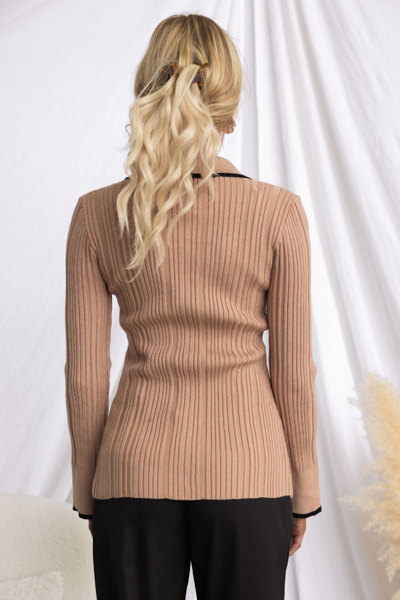 Back view of Shilah Ribbed Knit Top in beige, featuring a collar and fitted design, styled with sleek black pants.
