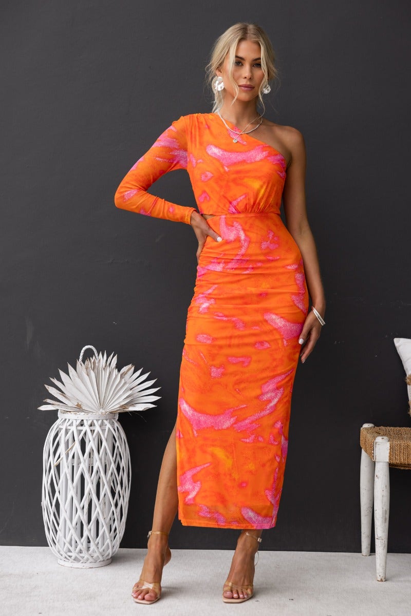 One-shoulder orange maxi dress with cut-out waist, side split, and stretch fabric on model, perfect for summer events.