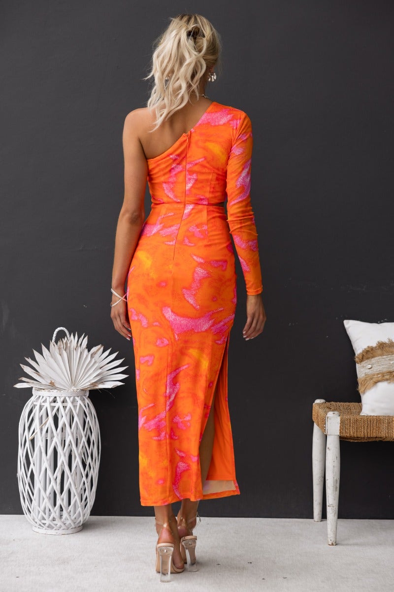 Back view of a one-shoulder orange and pink maxi dress with side split and fitted silhouette.