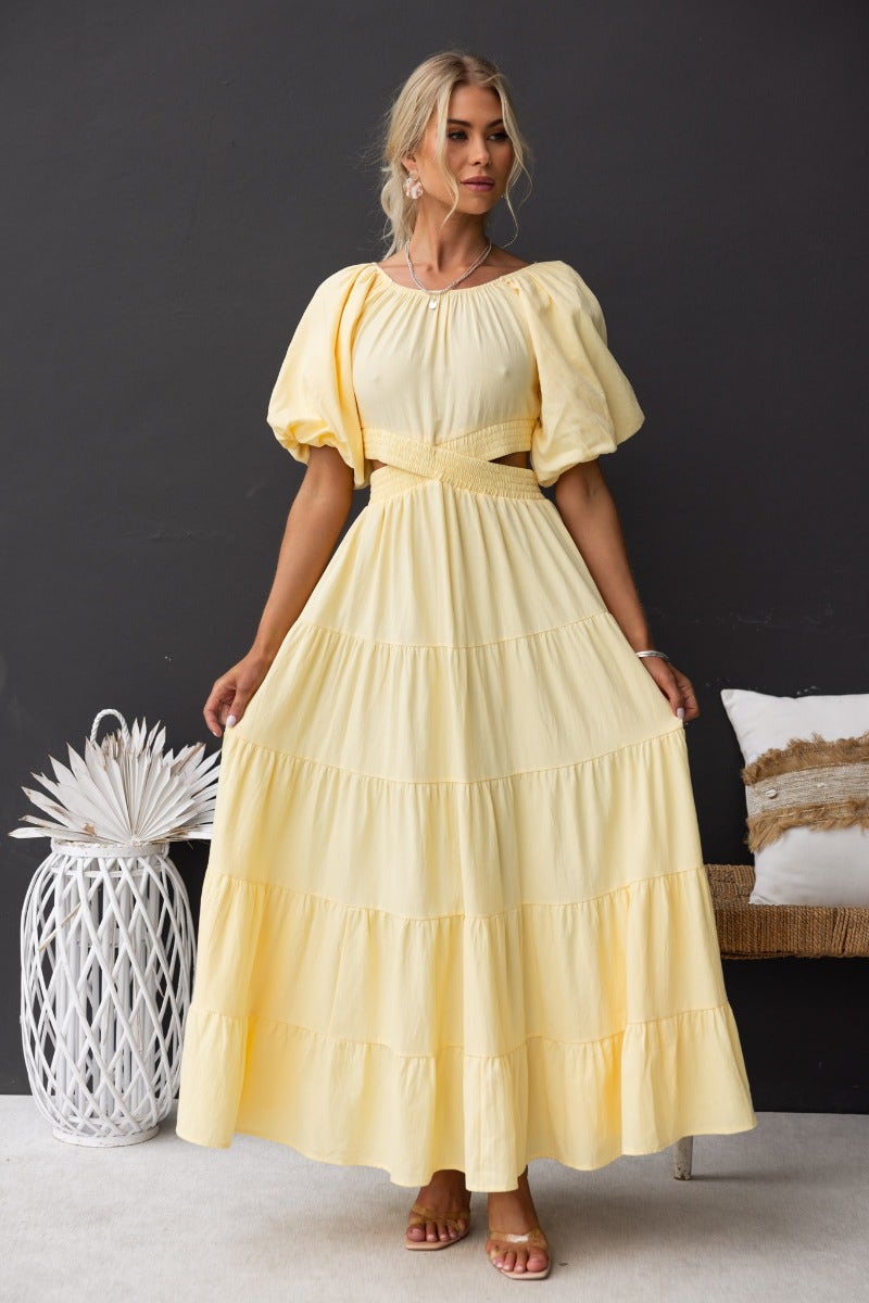 Posh maxi dress in soft yellow with elastic off-shoulder neckline and tiered design, perfect for summer occasions.